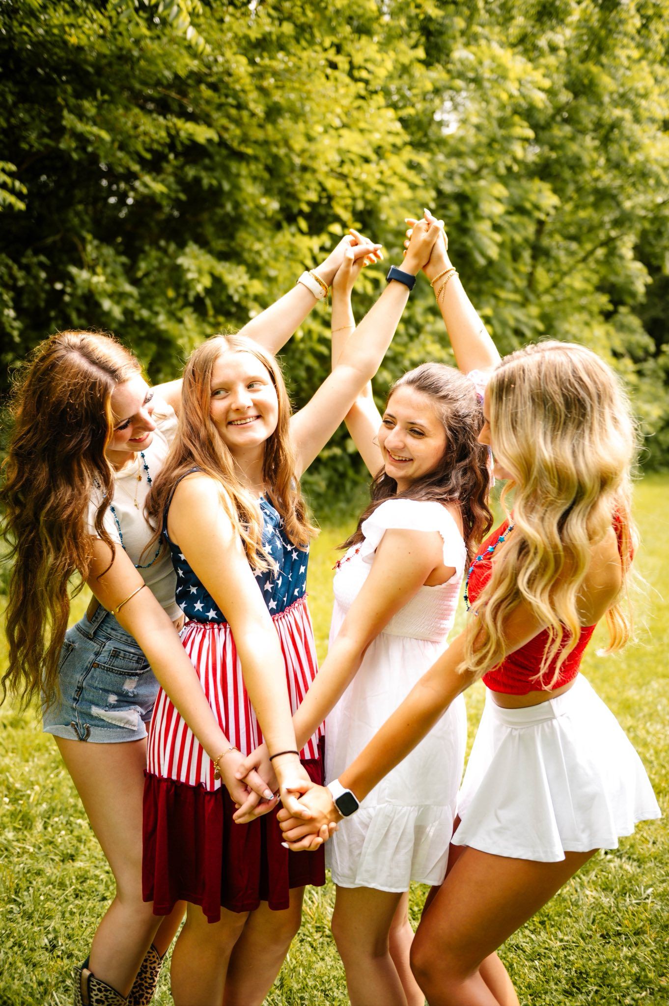 Group celebrating outdoors in patriotic attire on a sunny summer day.