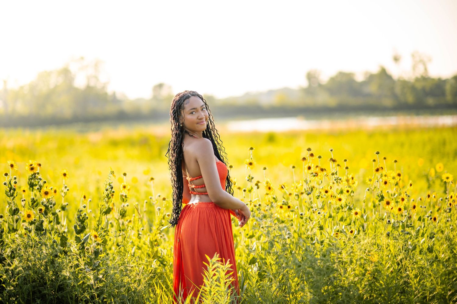 Summer portrait in a field of yellow wildflowers during golden hour.