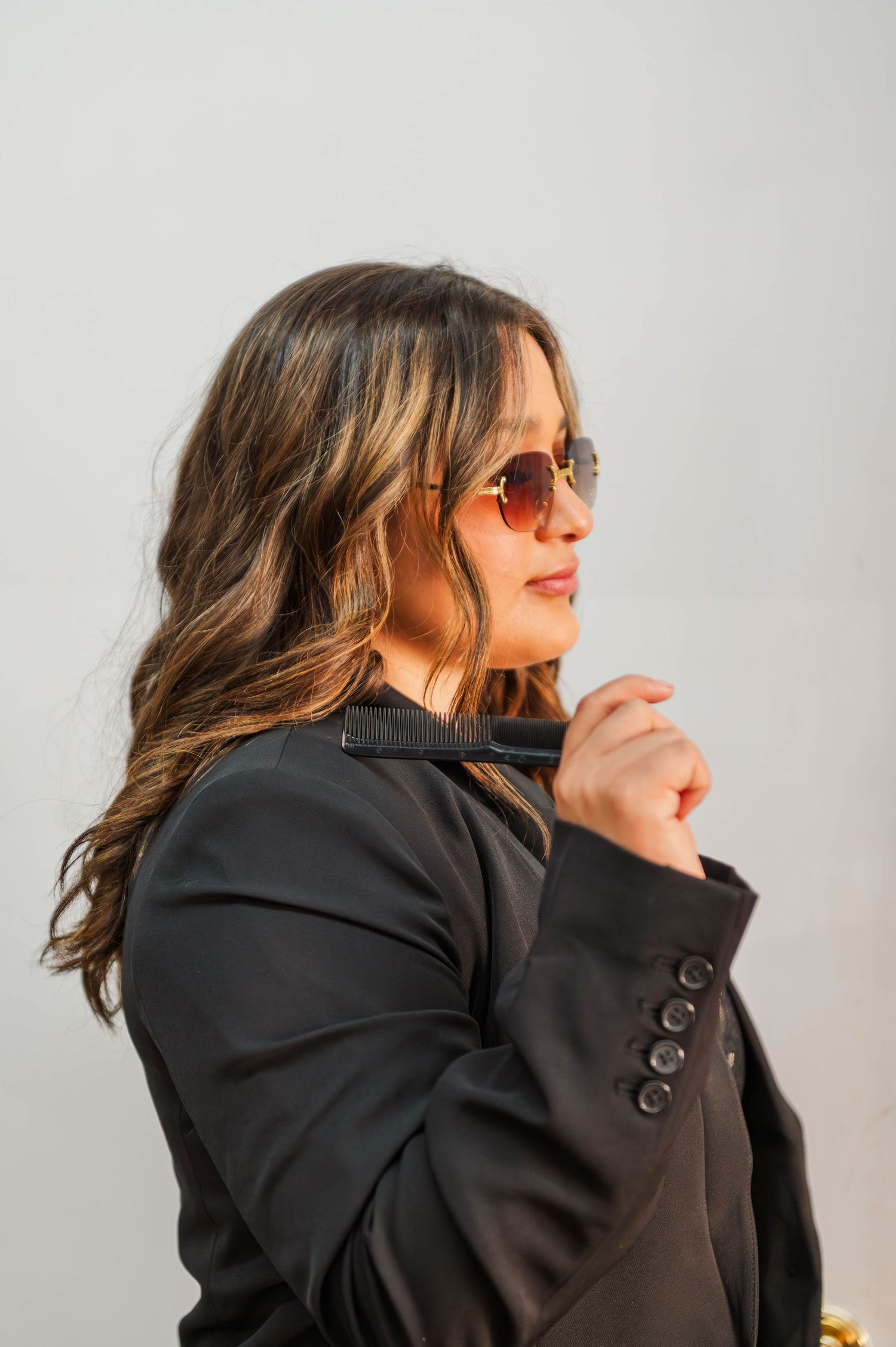 Side profile shots against white background wearing black blazer.