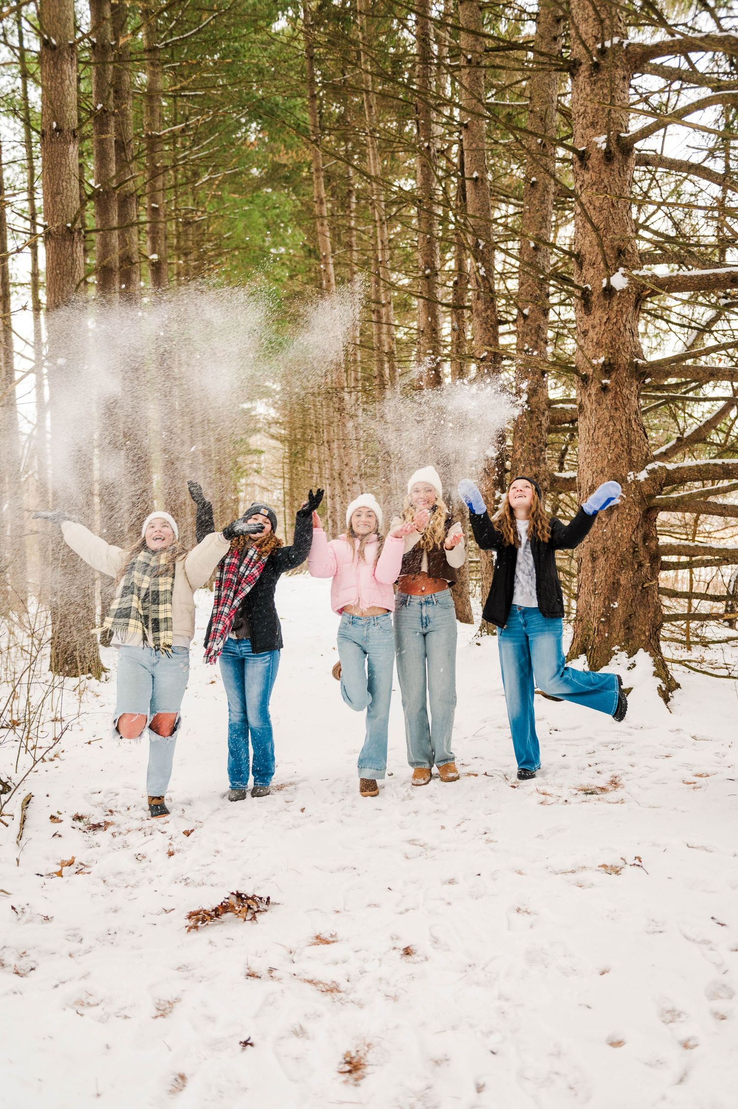 Candid group photos in a snow-covered forest with pine trees creating a natural backdrop.