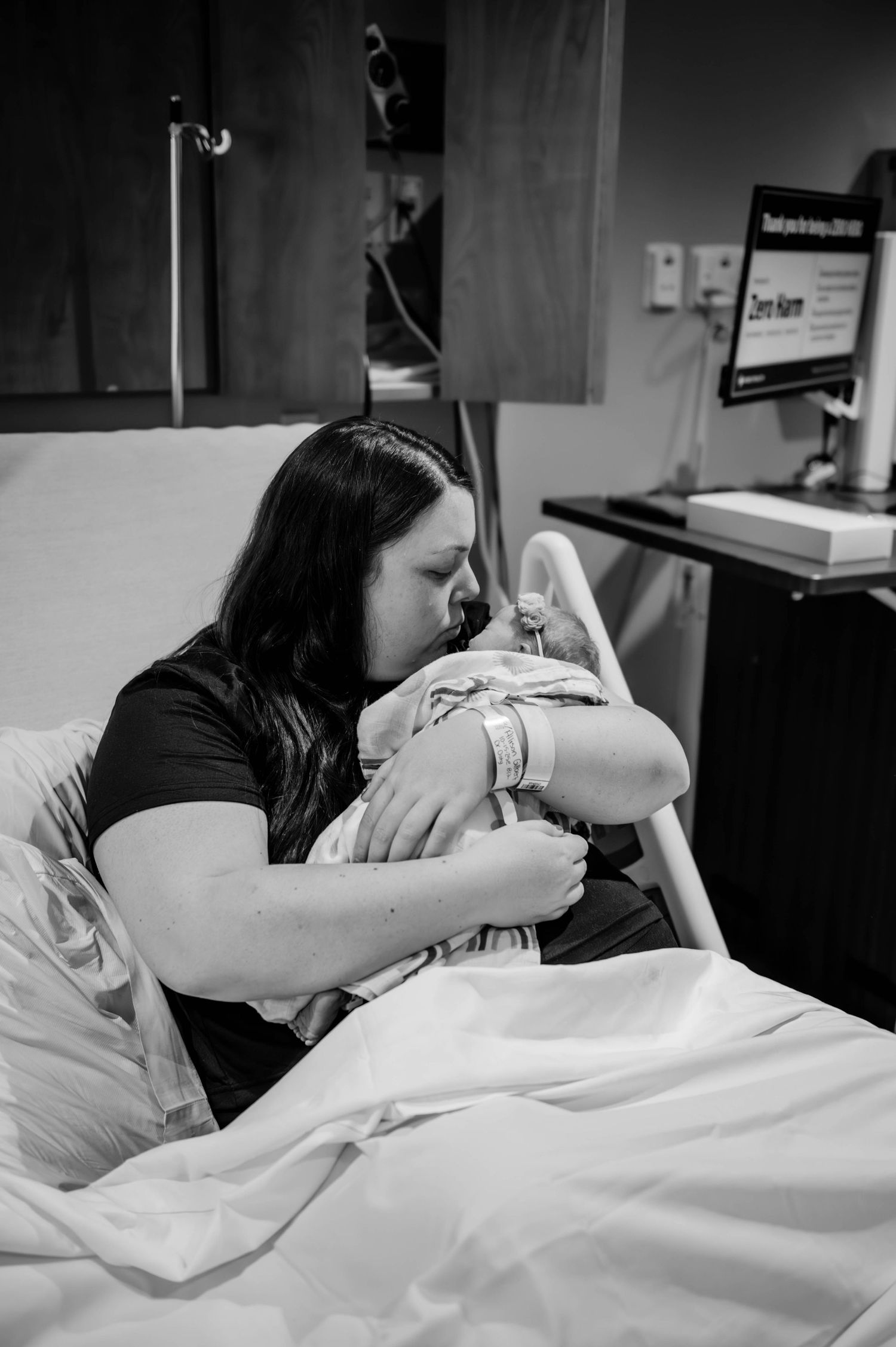 Black and white photo of a hospital room with medical equipment and a patient in bed.