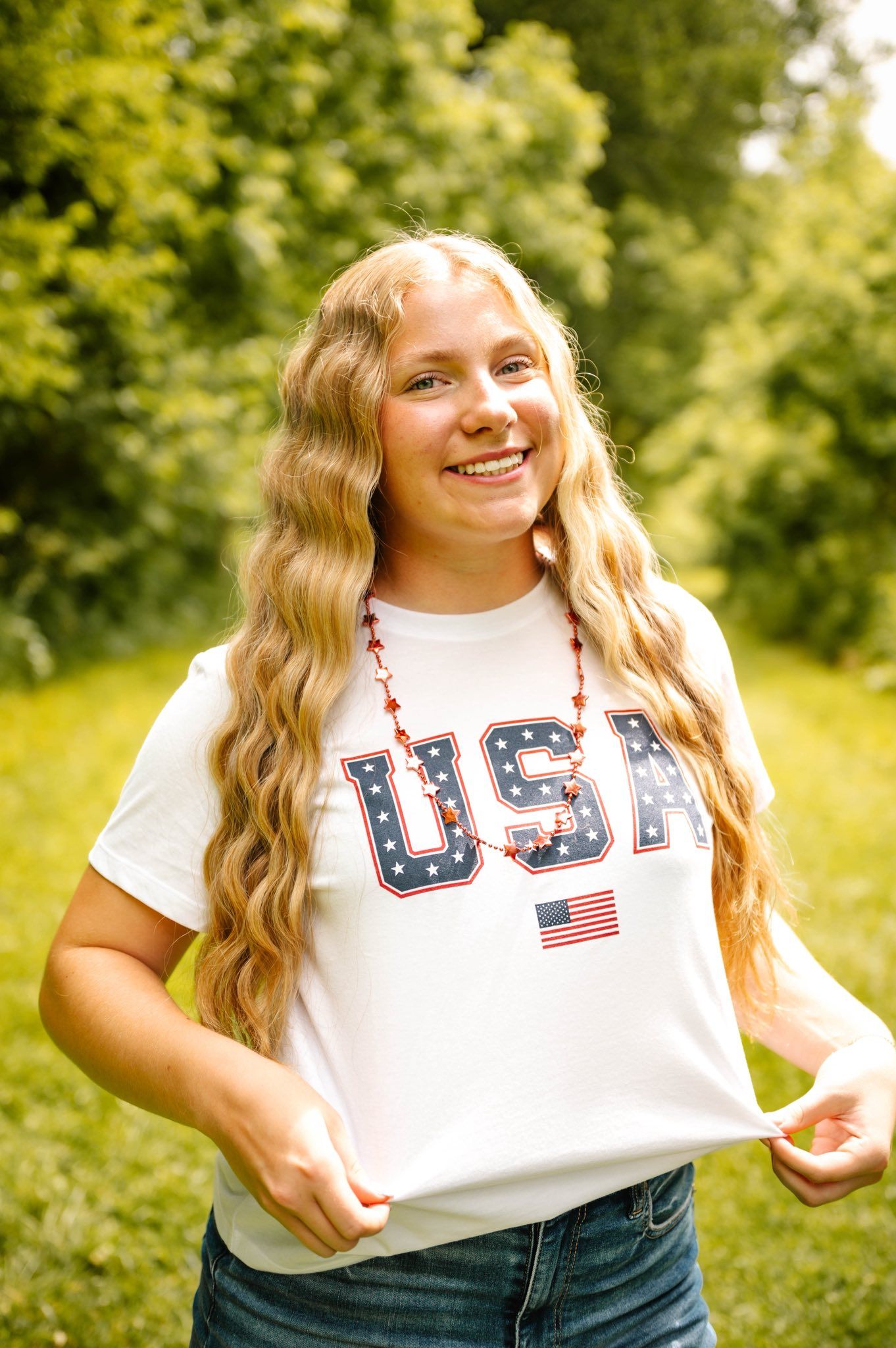 A patriotic USA shirt being modeled outdoors in a natural setting.