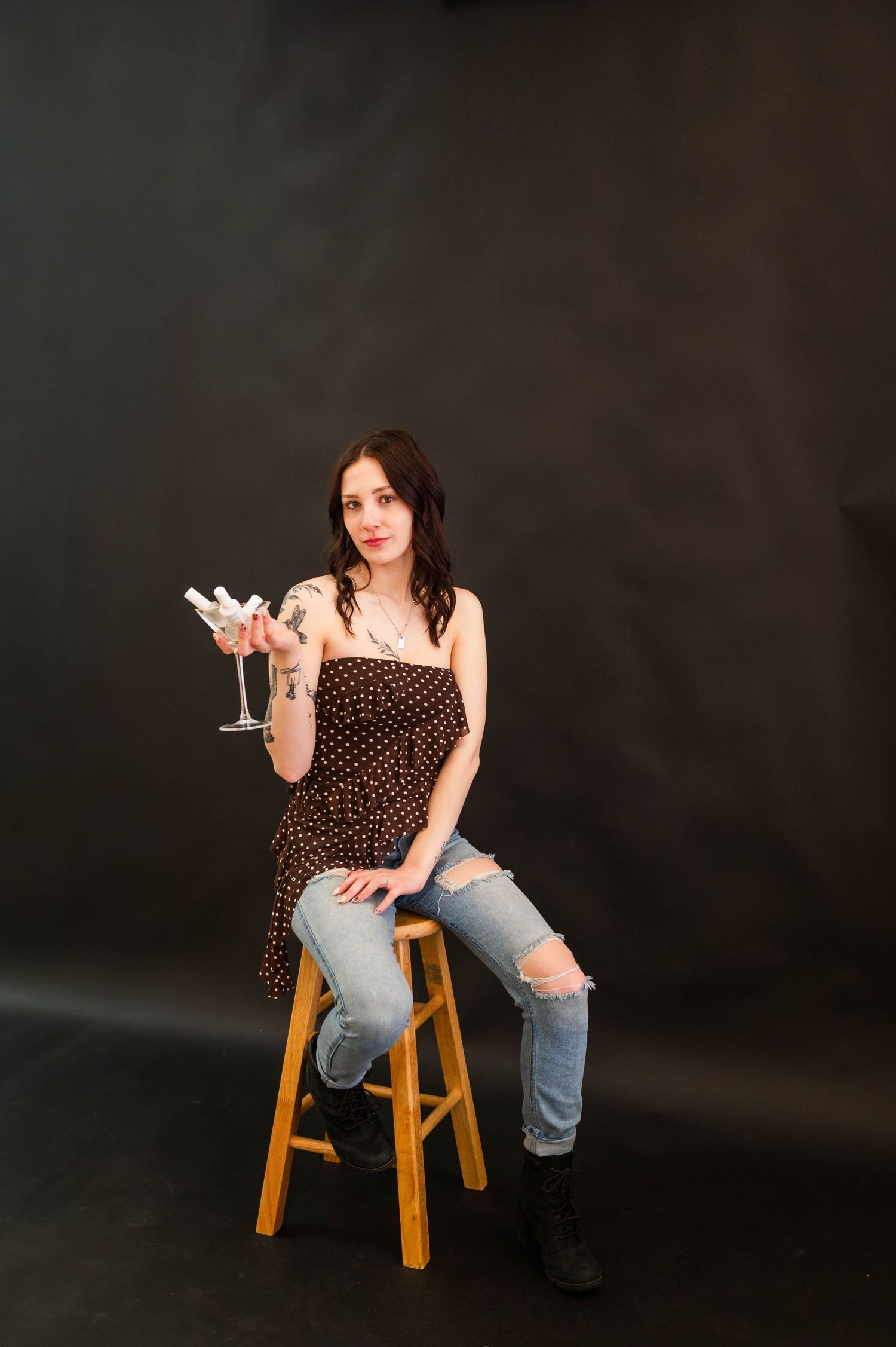 Studio photoshoot featuring a wooden stool against dark backdrop.