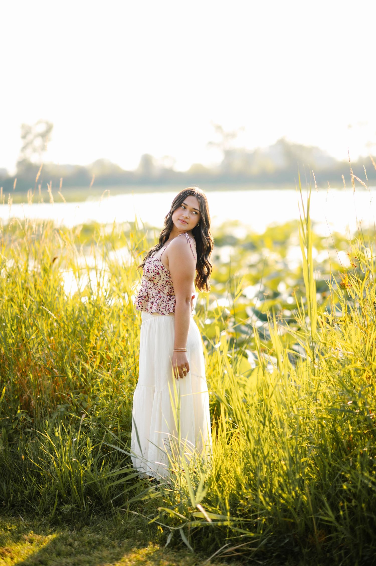 Ethereal portrait in a sunlit meadow with tall yellow wildflowers.