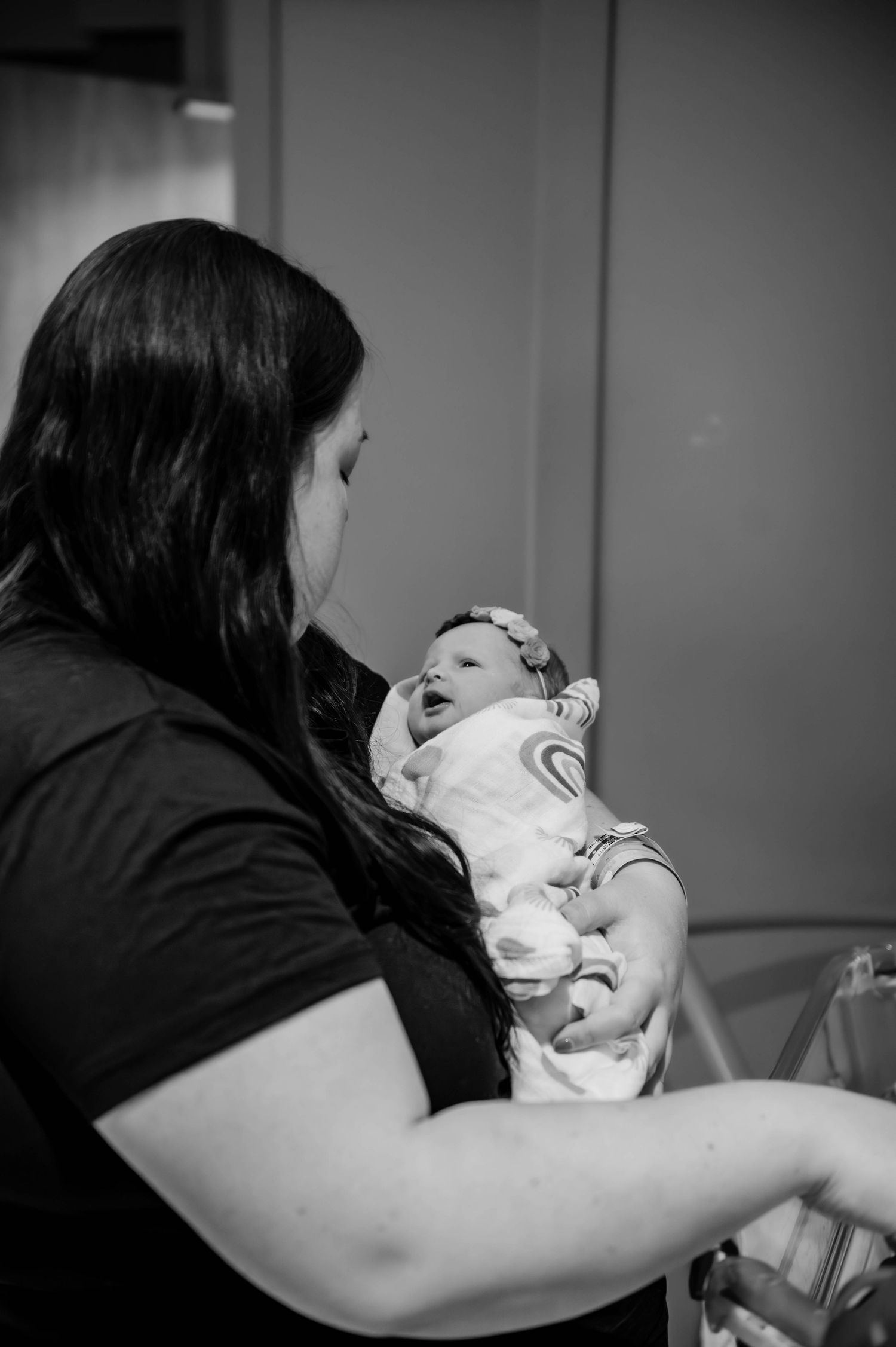 Black and white photo of a caregiver holding and comforting a newborn.