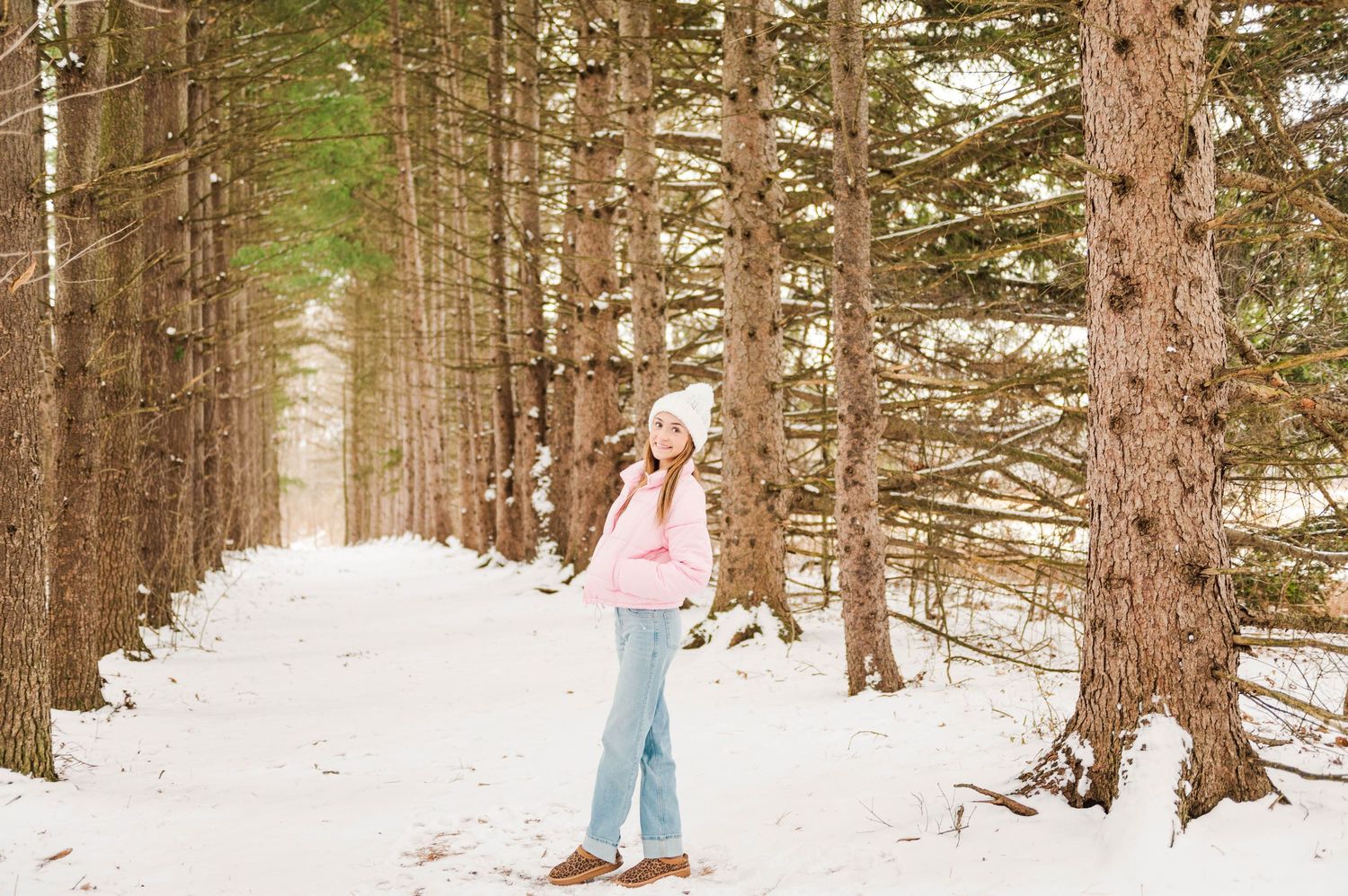 A winter photoshoot in a snowy forest with pine trees creating a beautiful natural backdrop.