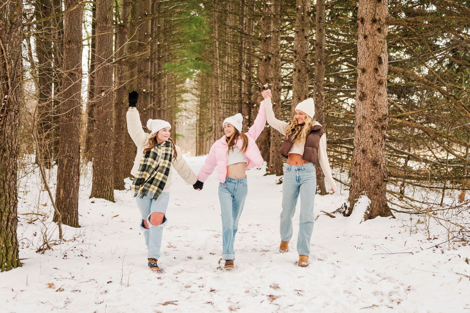 Snow-covered forest path with winter fashion photoshoot.