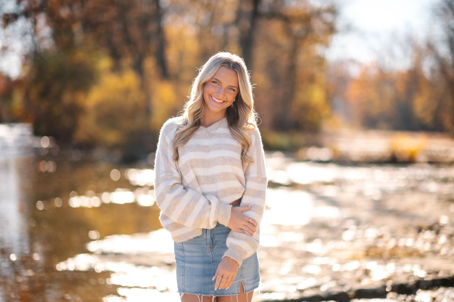 Scenic fall photoshoot with warm sunlight filtering through autumn trees.
