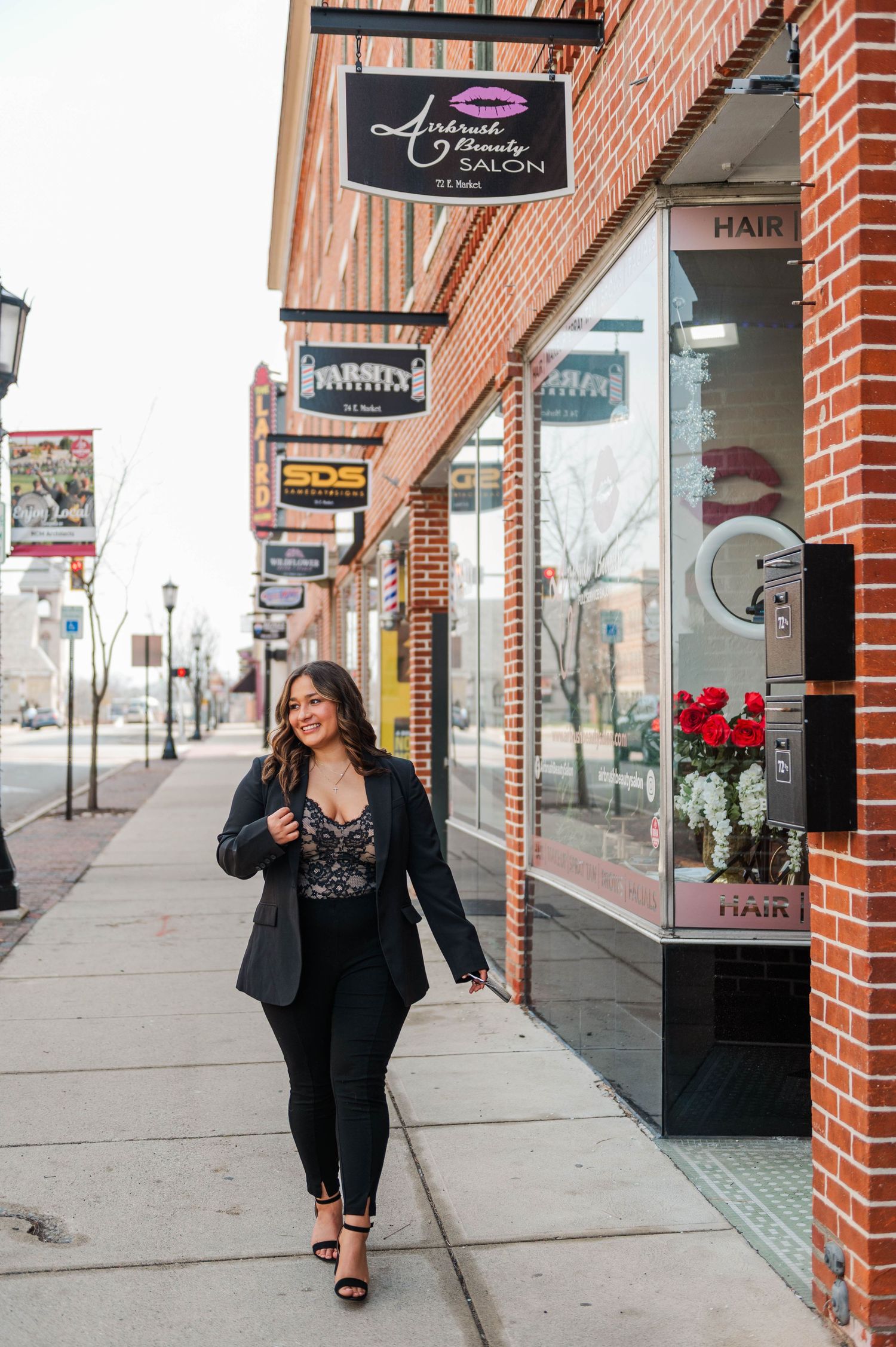 Professional storefront view of a beauty salon with brick exterior and black signage.