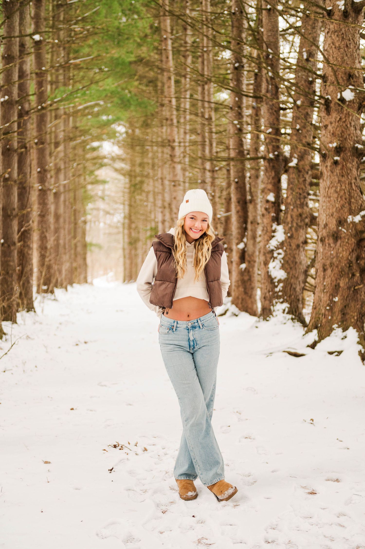 Winter fashion shoot featuring light denim and cozy winter wear in a snowy forest.