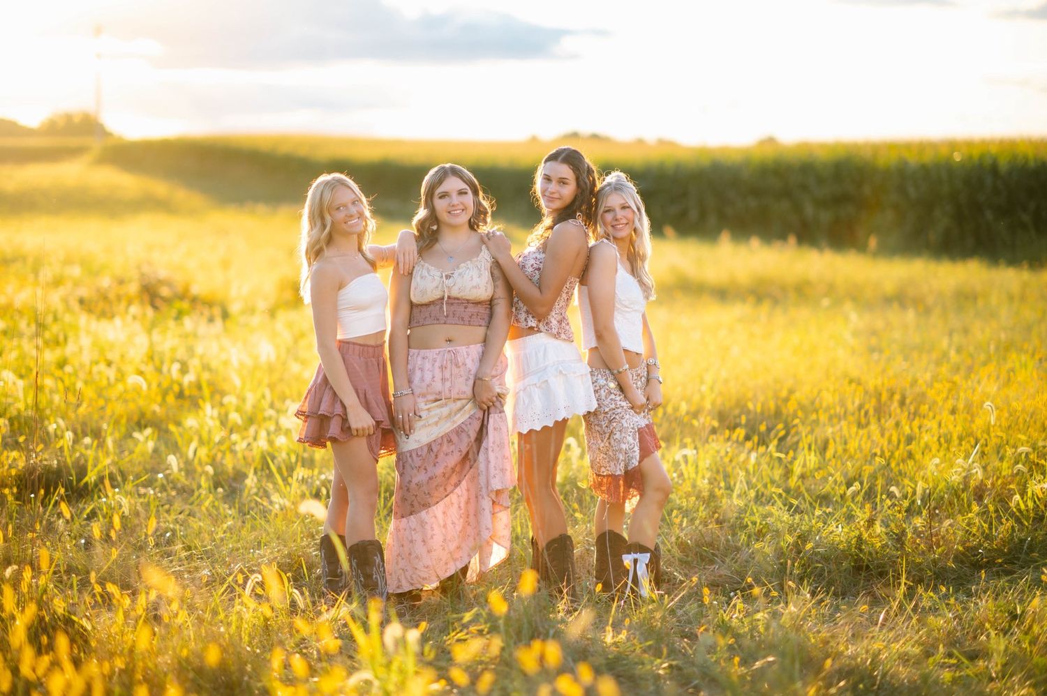 Friends walking together through a golden field at sunset creating a dreamy summer scene.