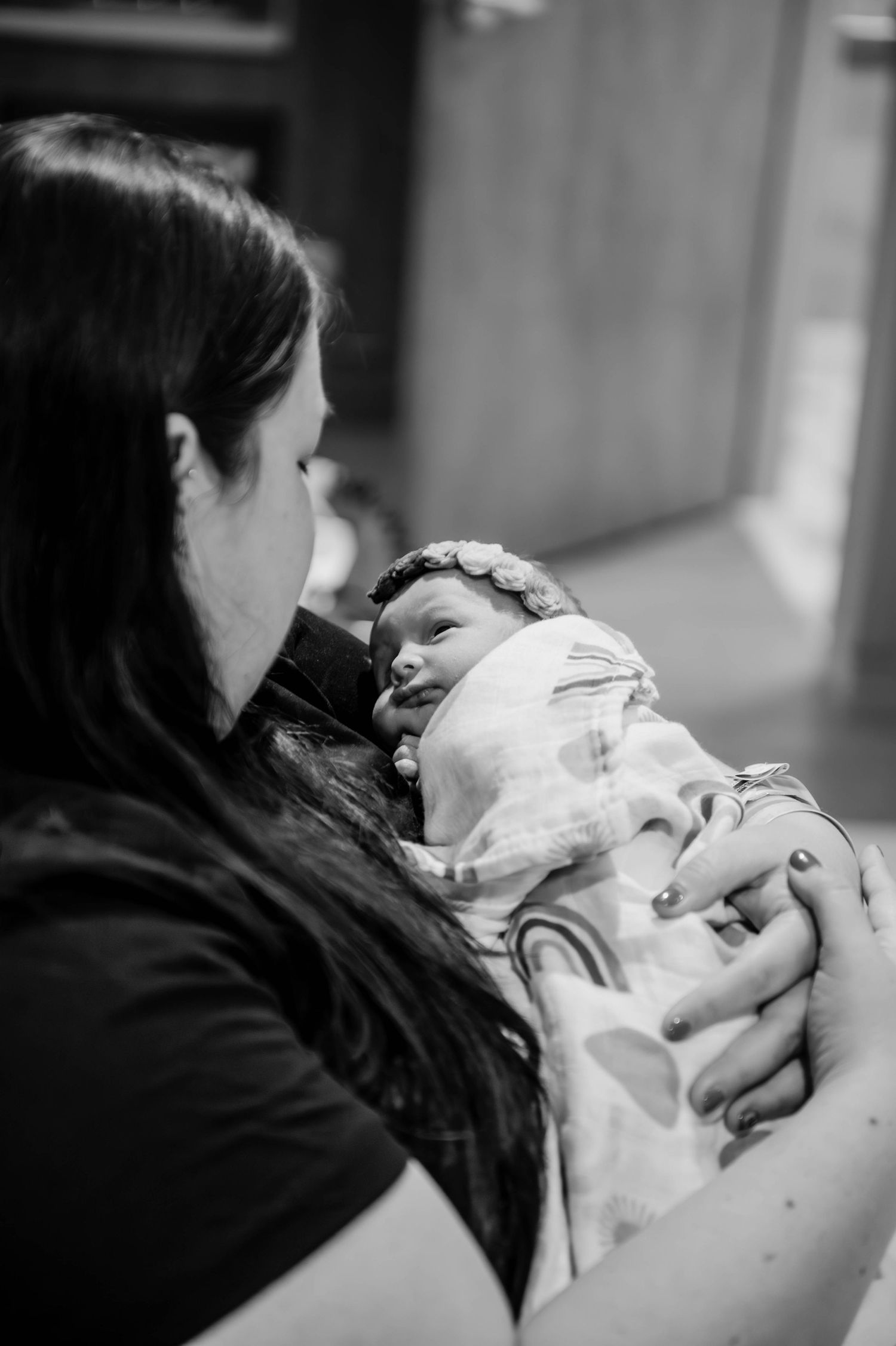 A tender moment between parent and newborn in black and white as they share their first moments together in the hospital.