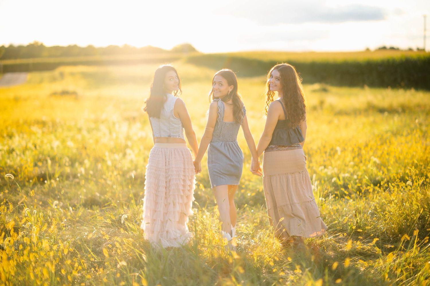 Group posing together in a sunlit meadow with golden light streaming through.