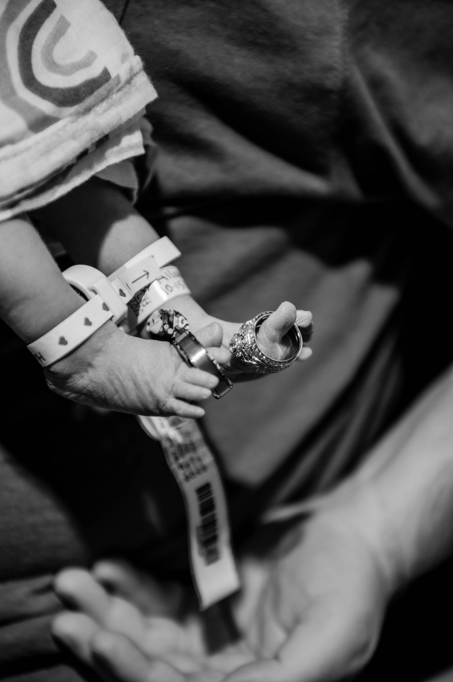 Black and white detail shot of hands holding small objects.