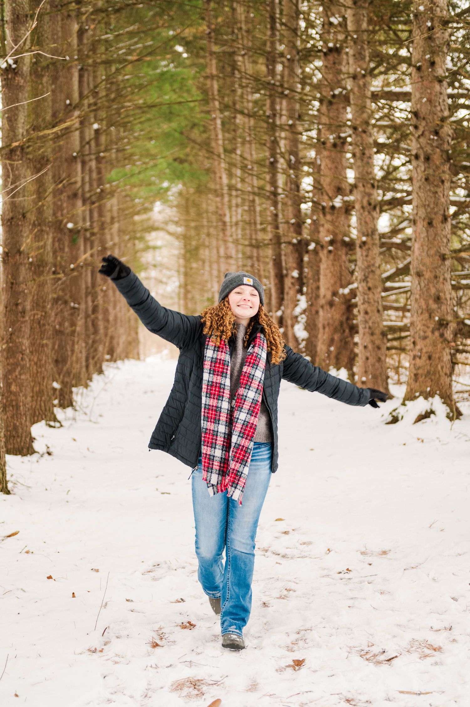 Playful poses in winter wonderland with snow covered pine trees.