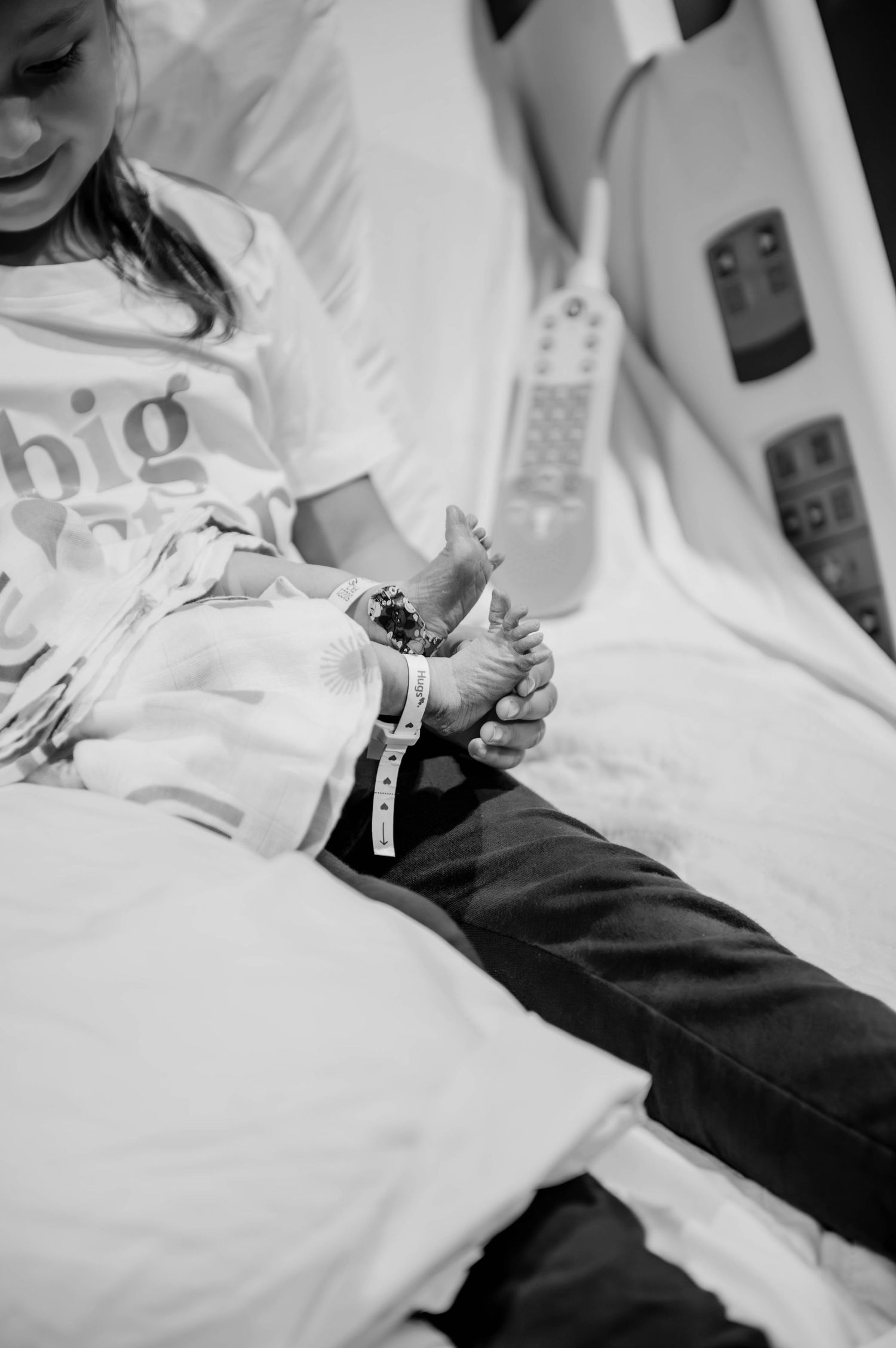 Close-up view of hospital bedding and medical equipment in black and white.