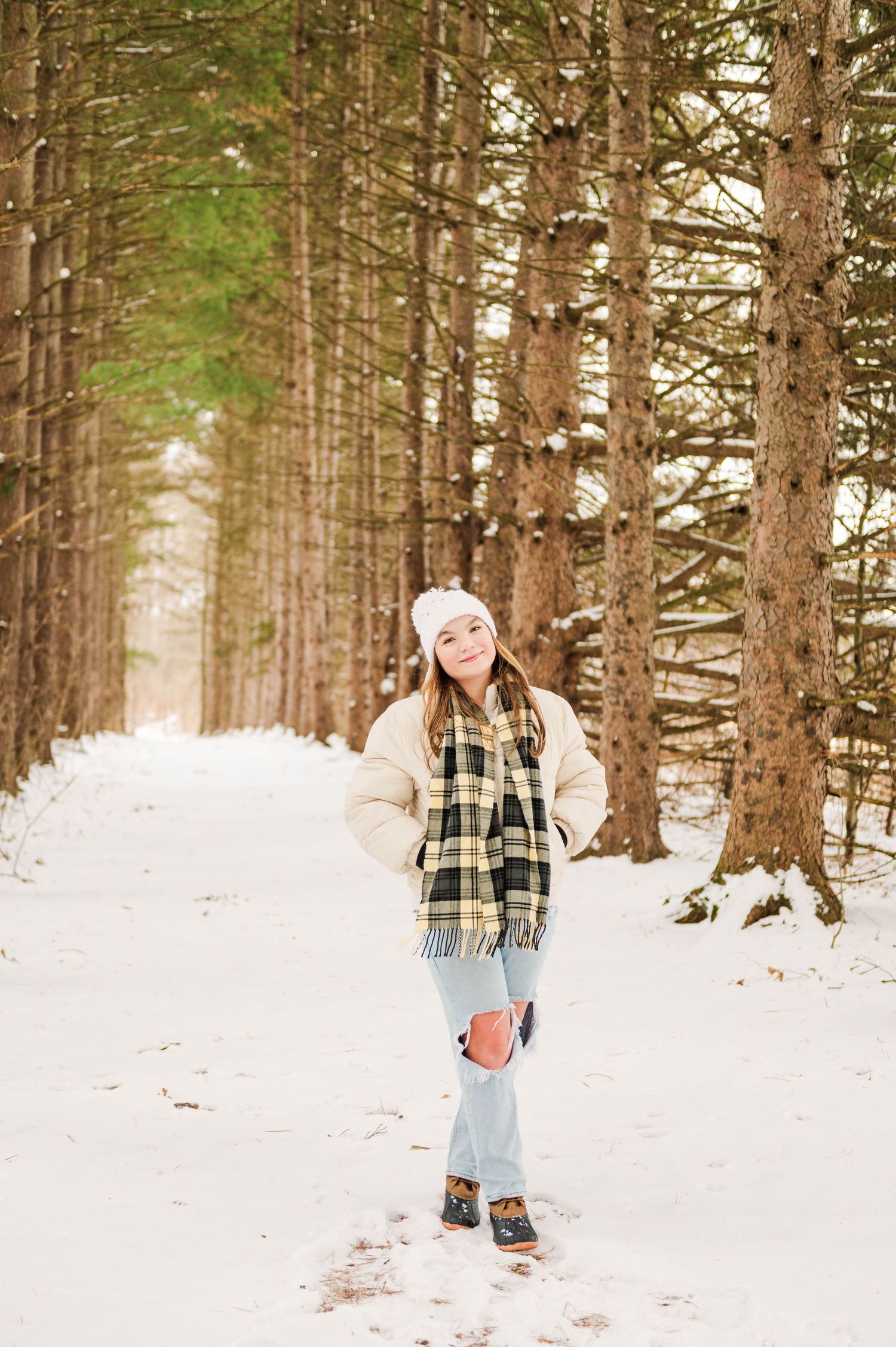 Casual winter fashion shoot among snow-covered pine trees.