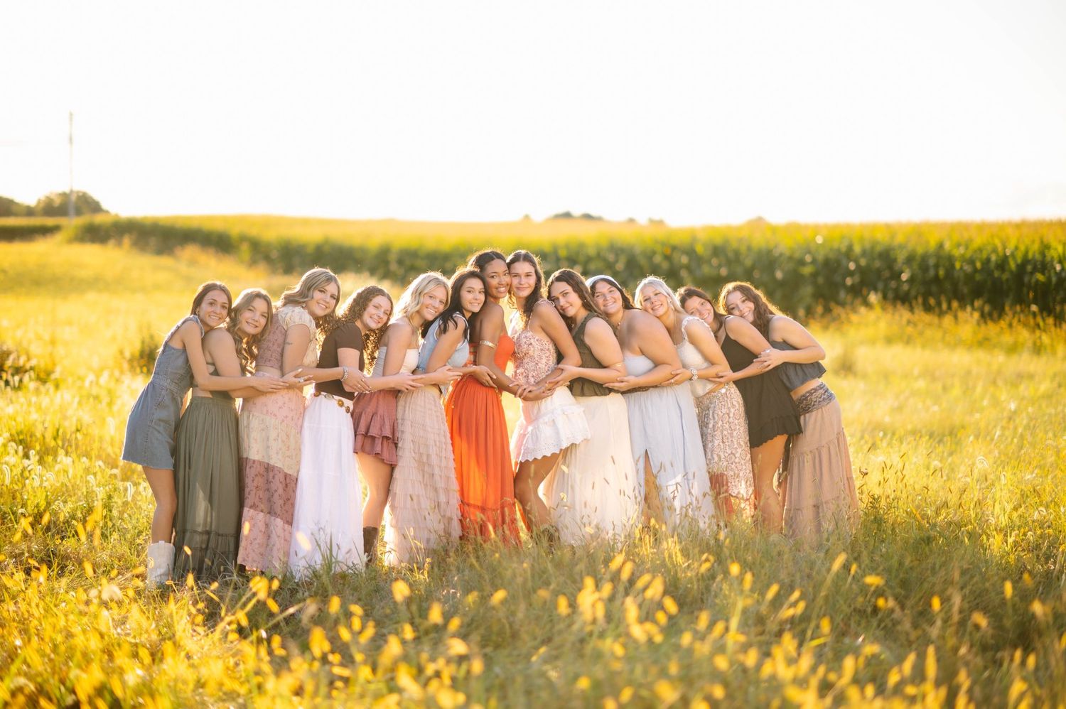 A group gathers together in a sun-soaked field at dusk.