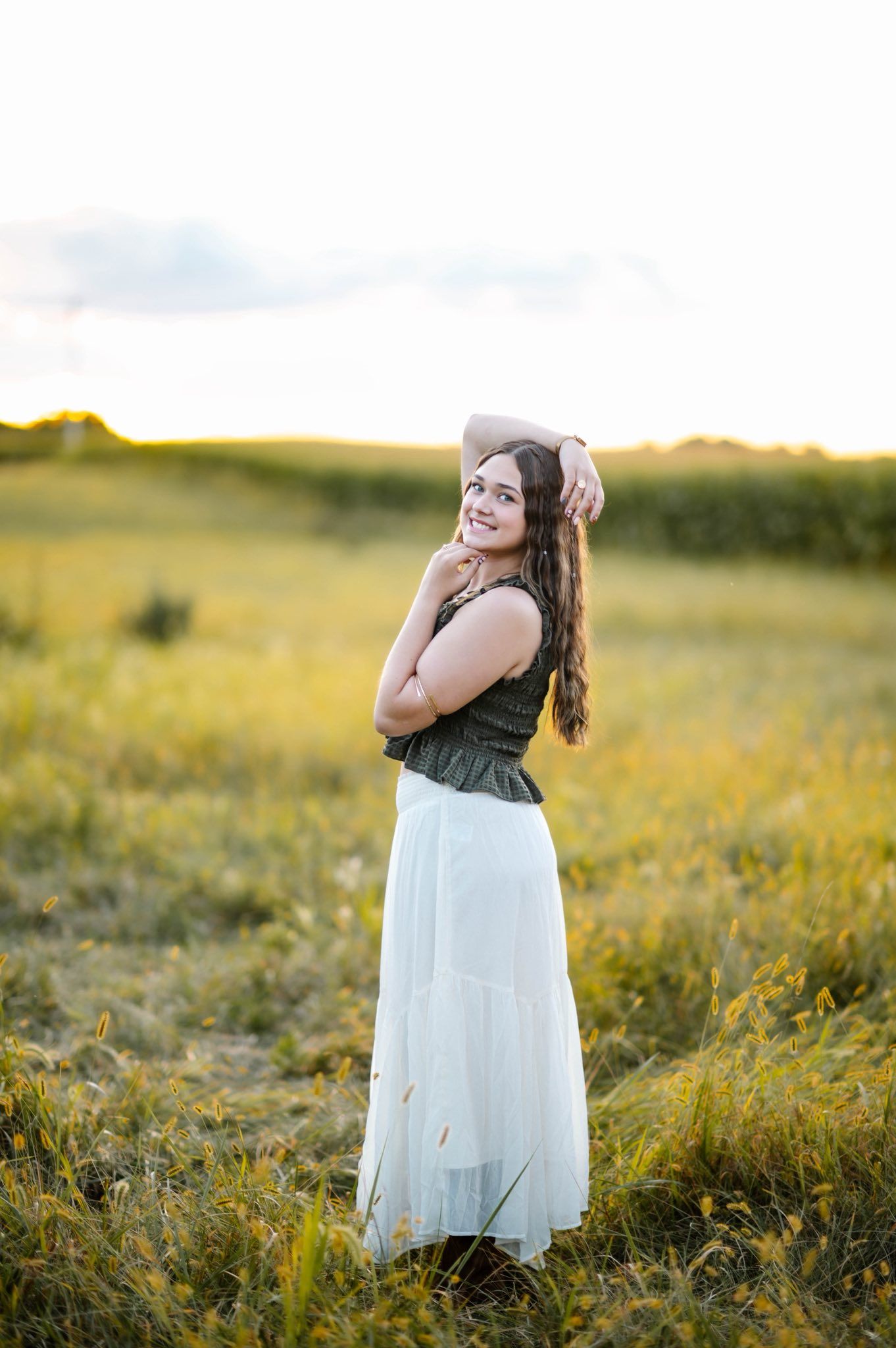 A flowing white dress catches the late afternoon light in a wildflower field.
