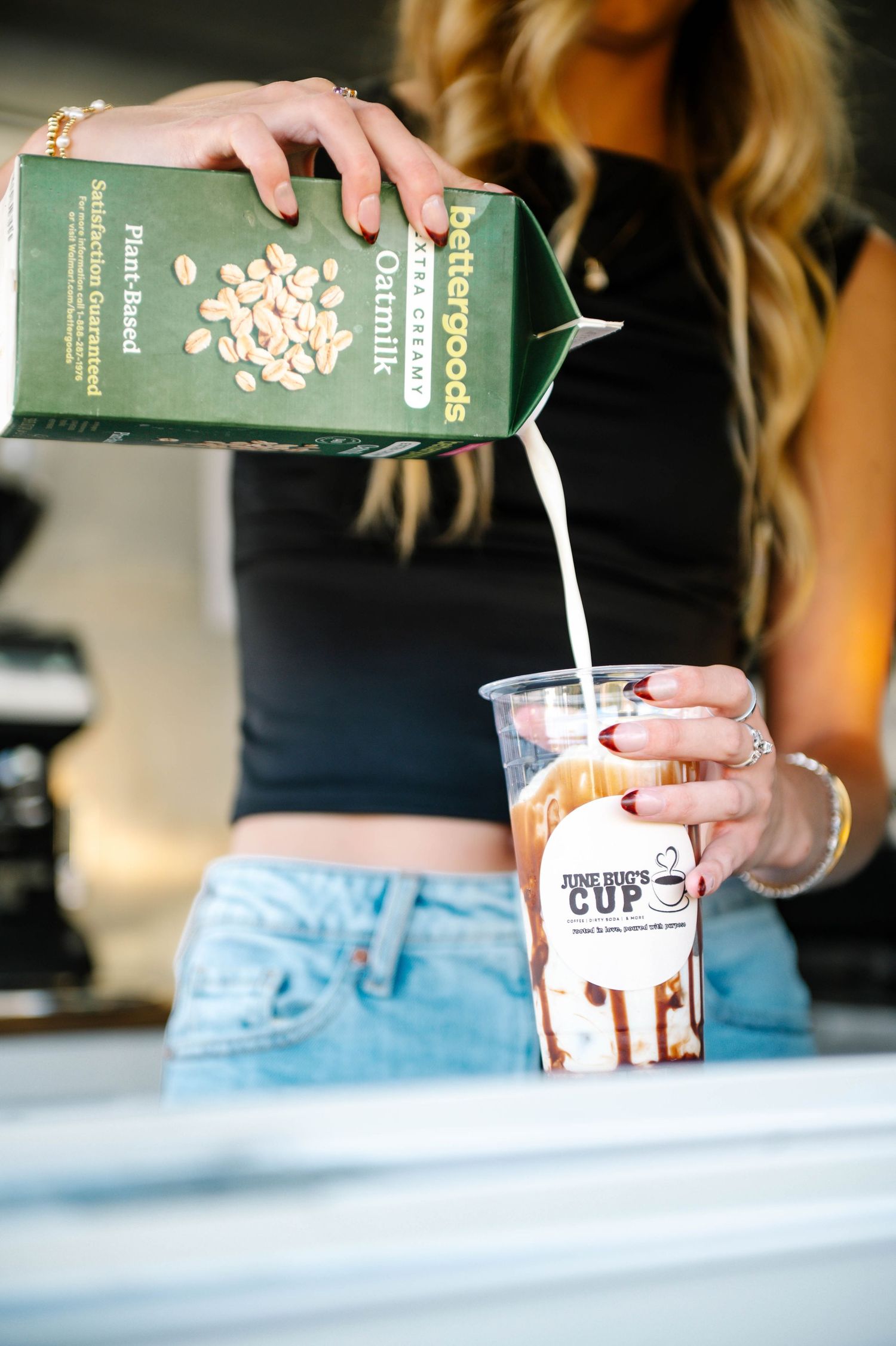 Person pouring milk from a carton into a plastic cup.