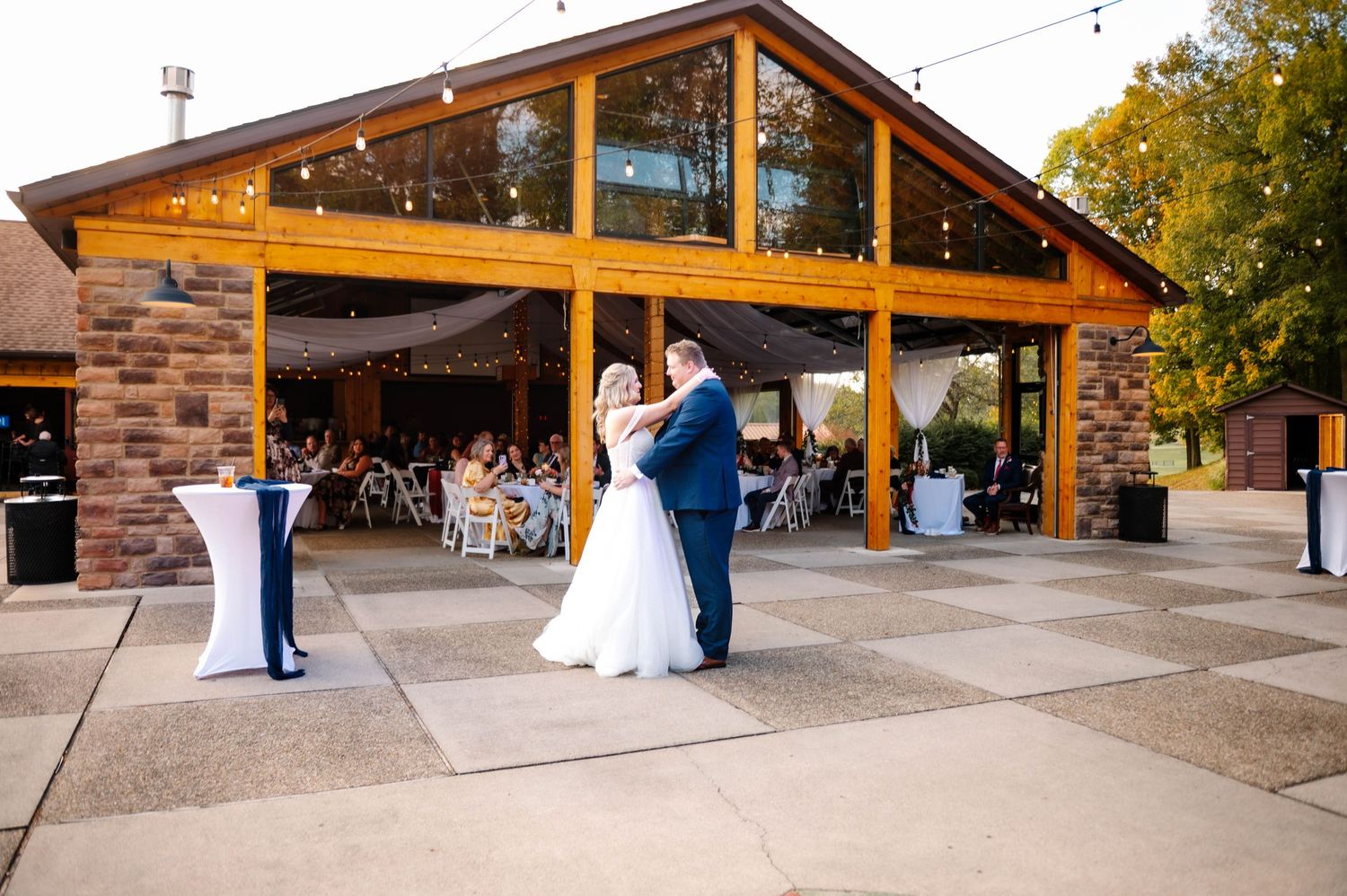 Rustic wedding venue with wooden beams and stone accents during daytime.