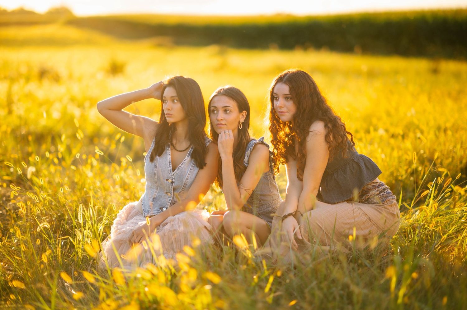 Friends relaxing together in a sun-soaked field during golden hour.