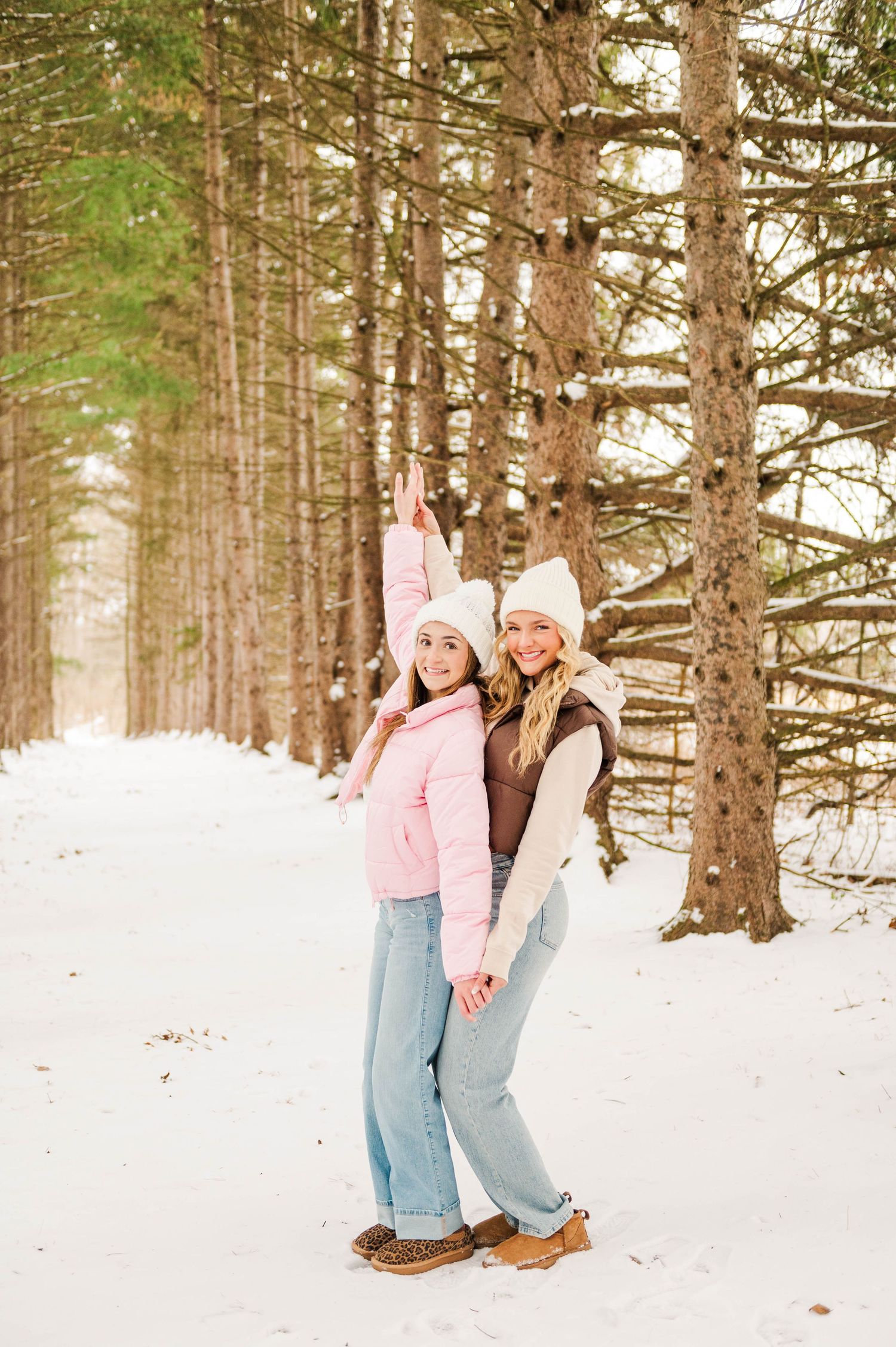 Playful winter photography session in pink and denim against snowy forest background.