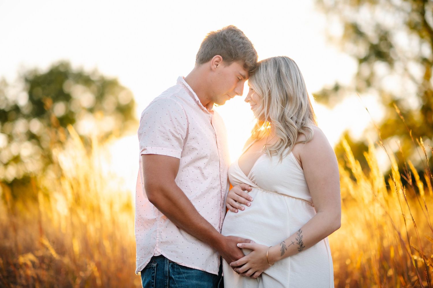 Intimate maternity portraits captured in warm evening sunlight.