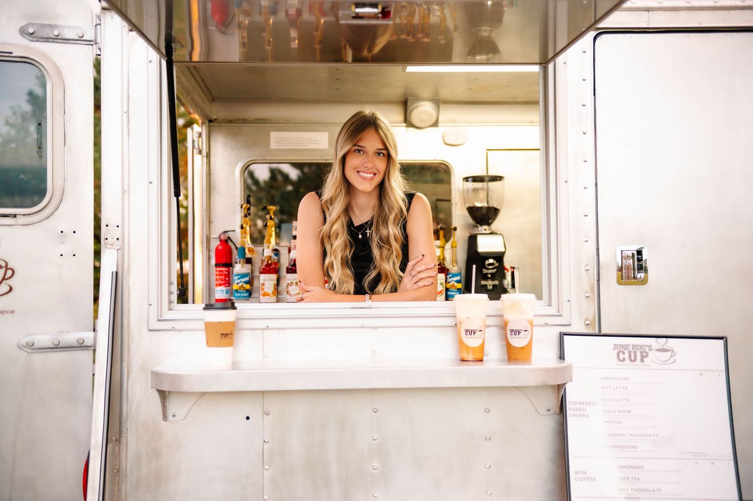 White food truck window serving coffee with menu board visible outside.