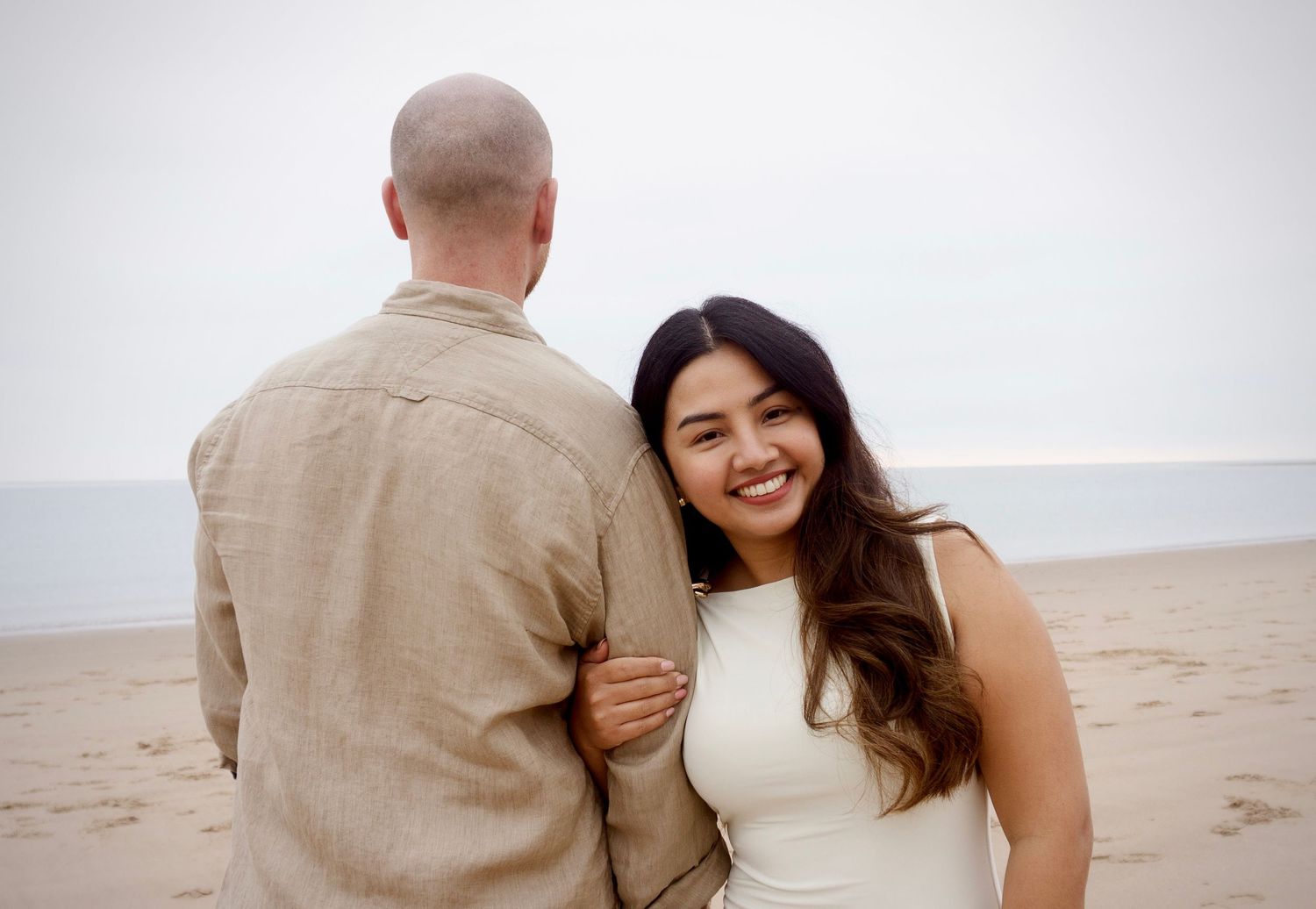 fiance smiling at camera during their photo session at the beach