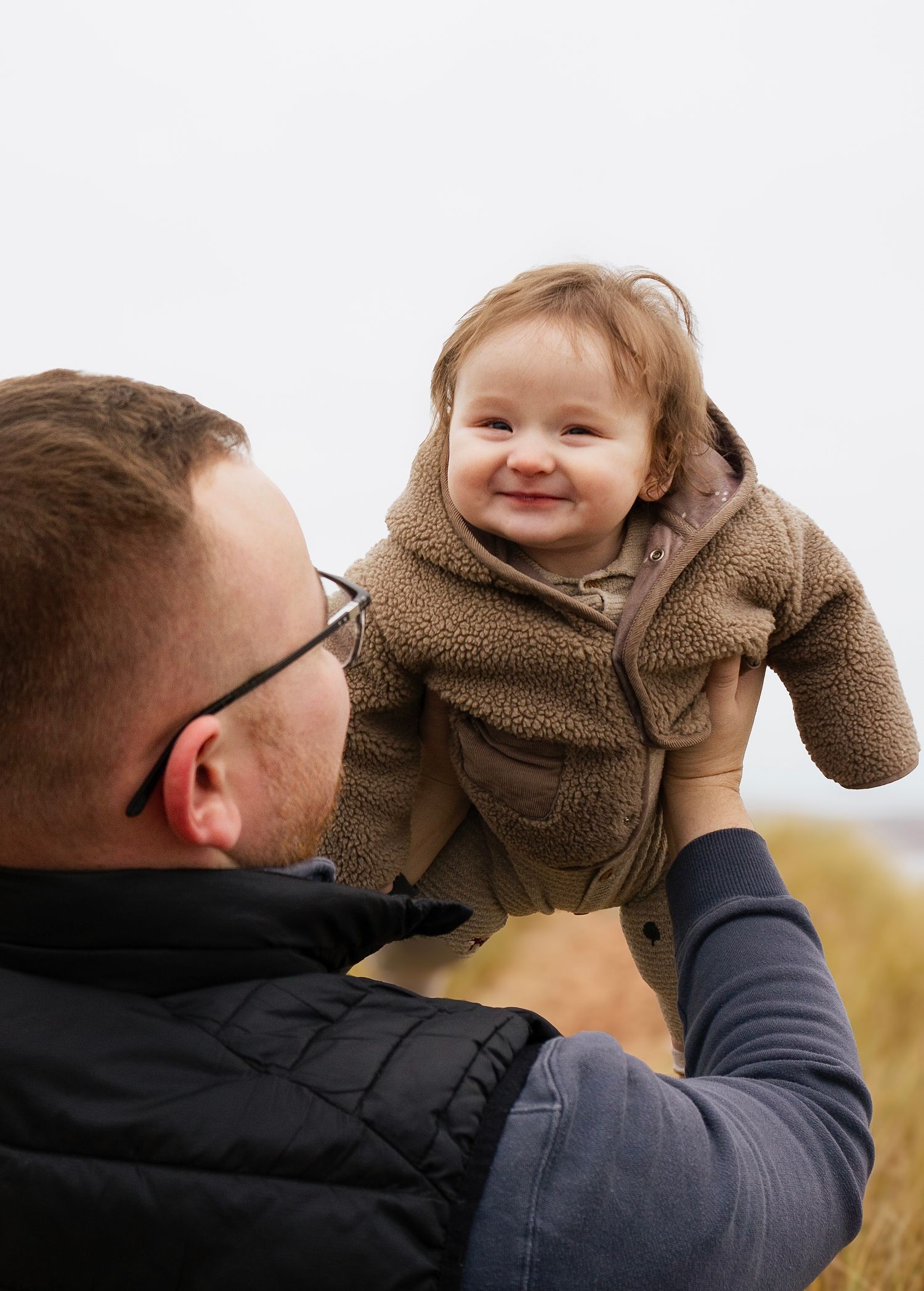 happy boy being lifted in the air by his dad