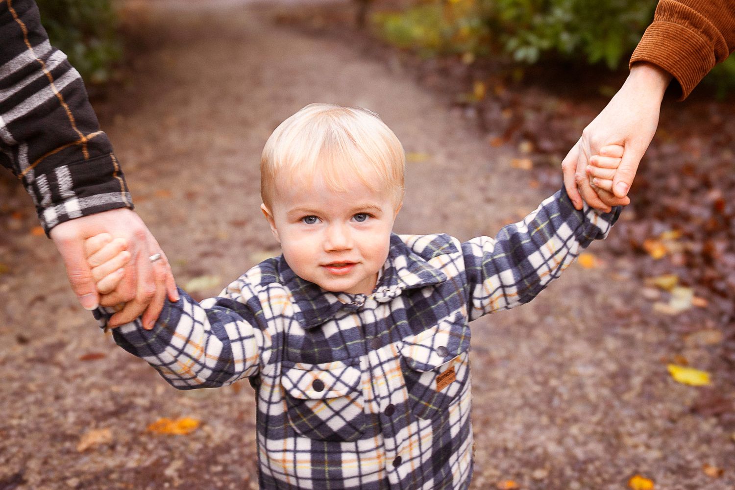 happy boy smiling during their family photo session in the woodlands