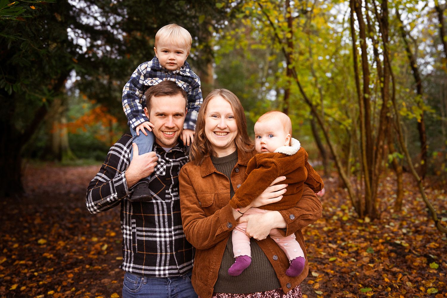 happy family smiling during their photo session in the woodlands