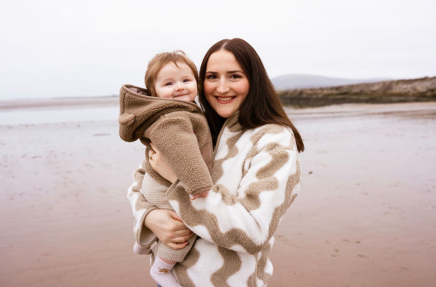 Baby and mom smiling during a warm, natural lifestyle photoshoot
