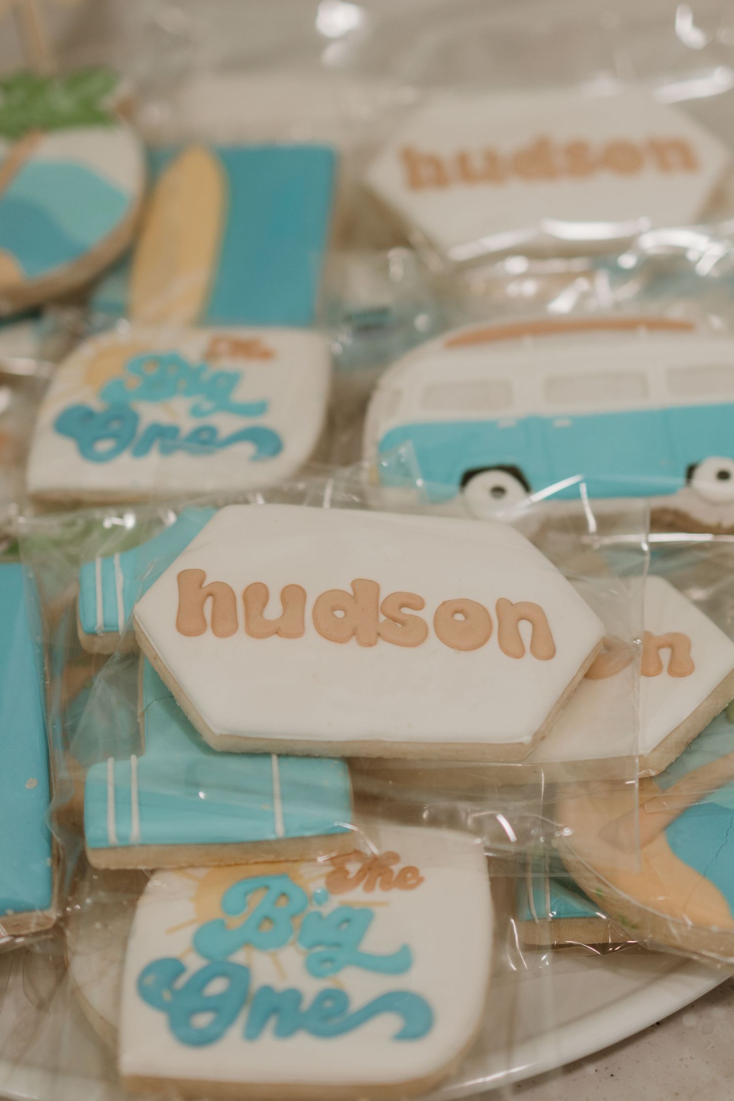 Custom Hudson first birthday surf-themed decorated sugar cookies in blue and white with VW van design.