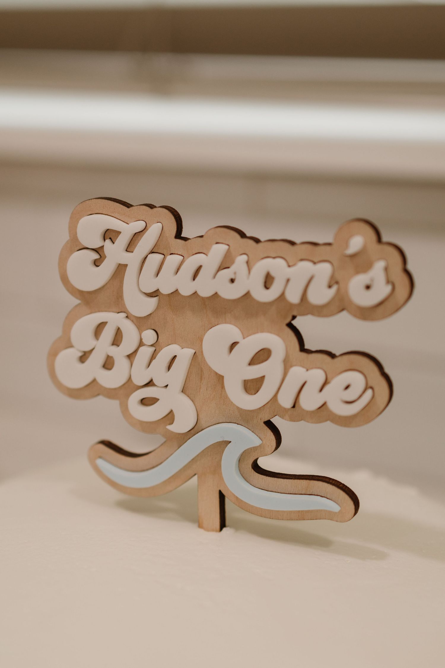 Wooden laser-cut Hudson Big One surf wave cake topper for first birthday party.