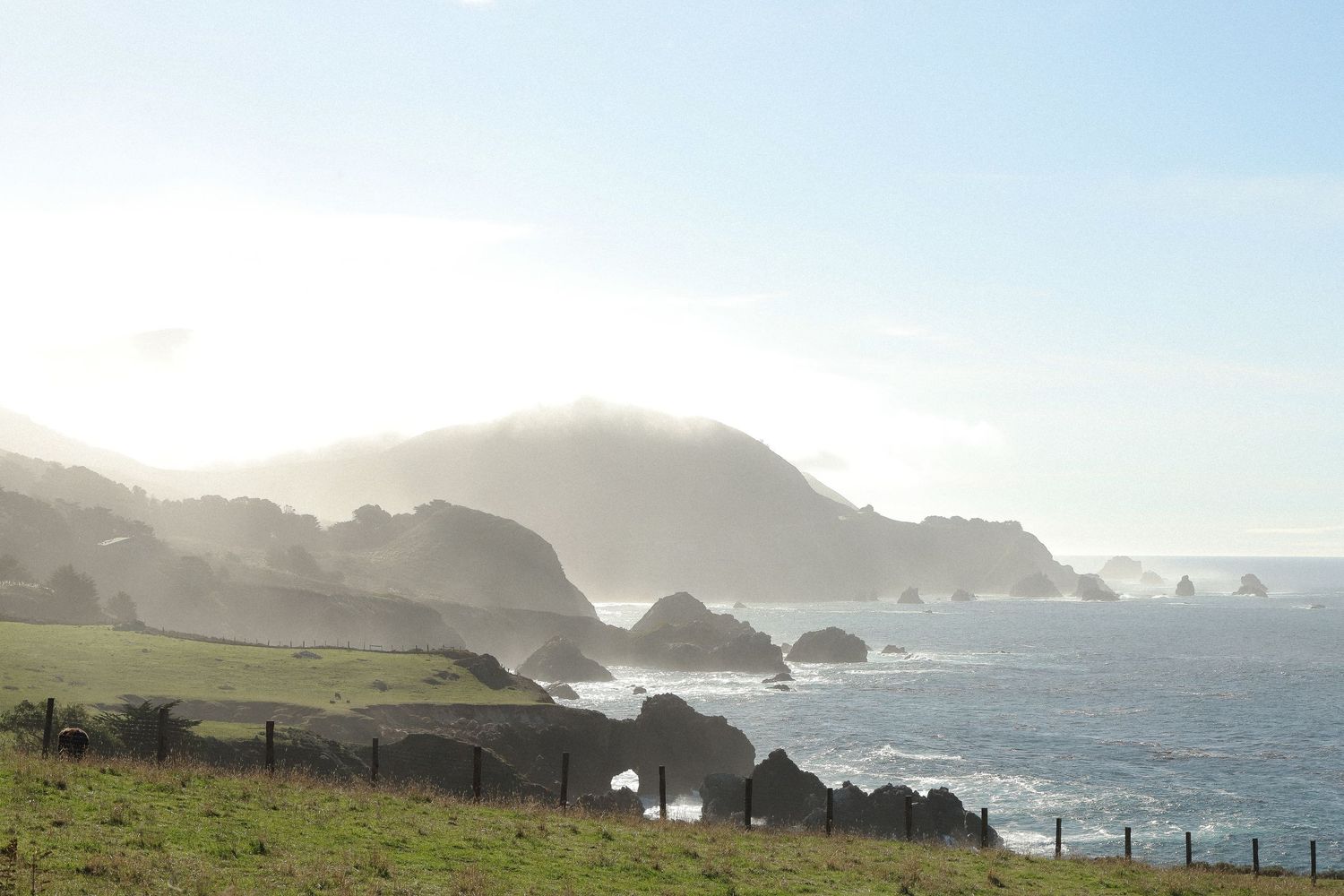 Dramatic coastal landscape with cliffs and crashing waves along the Pacific coastline.