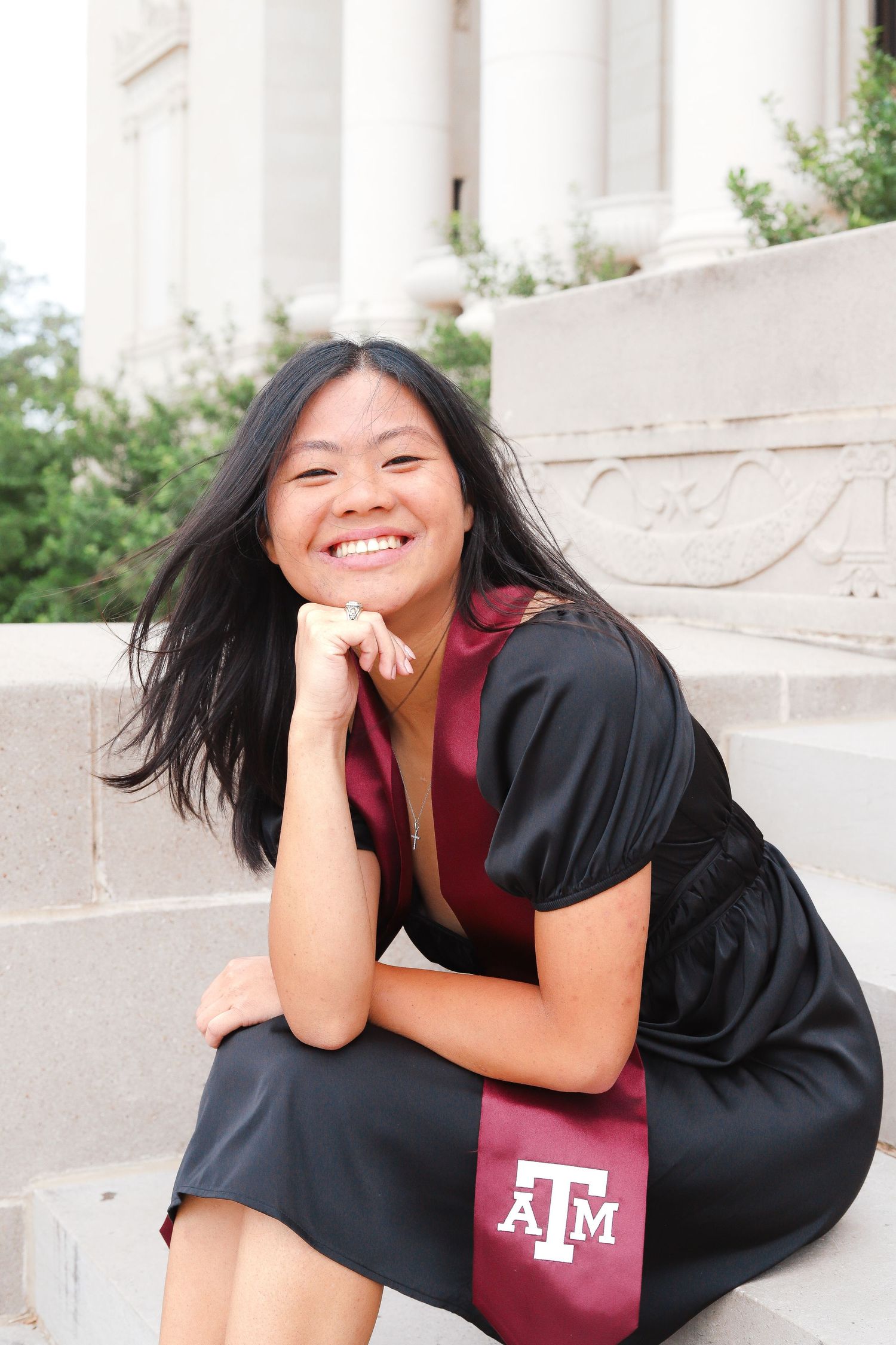 Portrait series showing joyful poses in graduation attire near white columns.