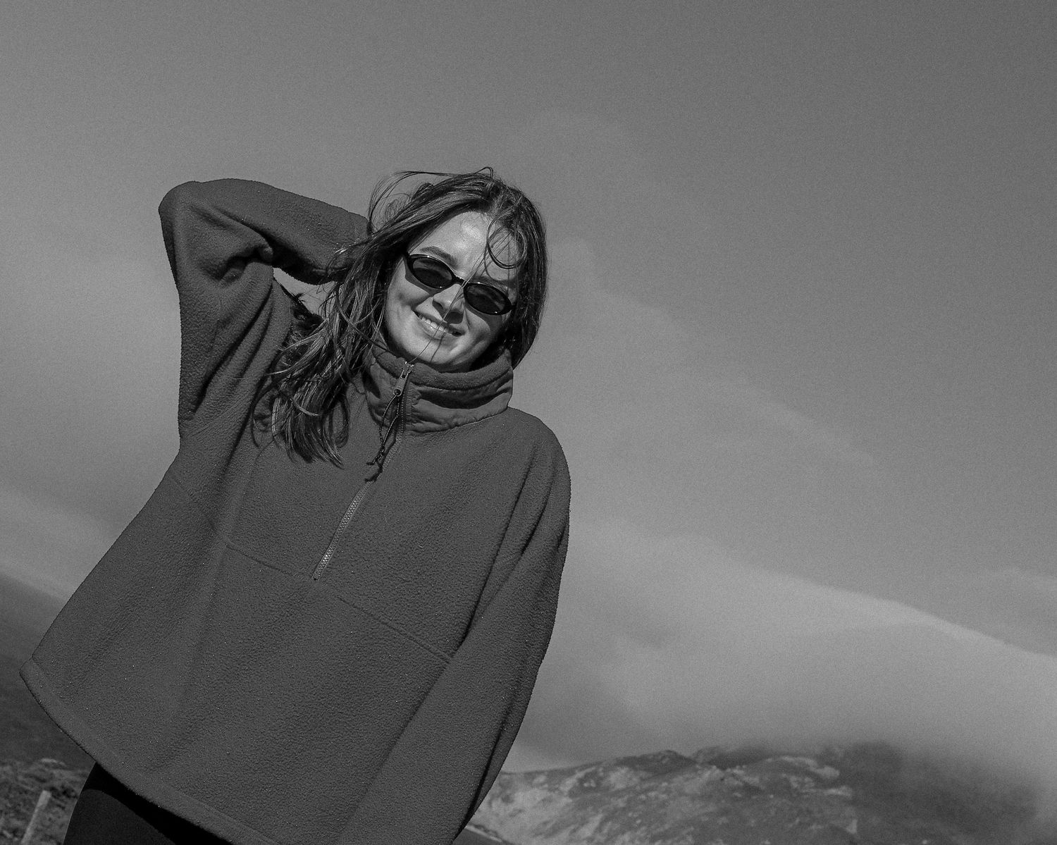 A black and white photo series showing someone lying down and posing in different casual positions.