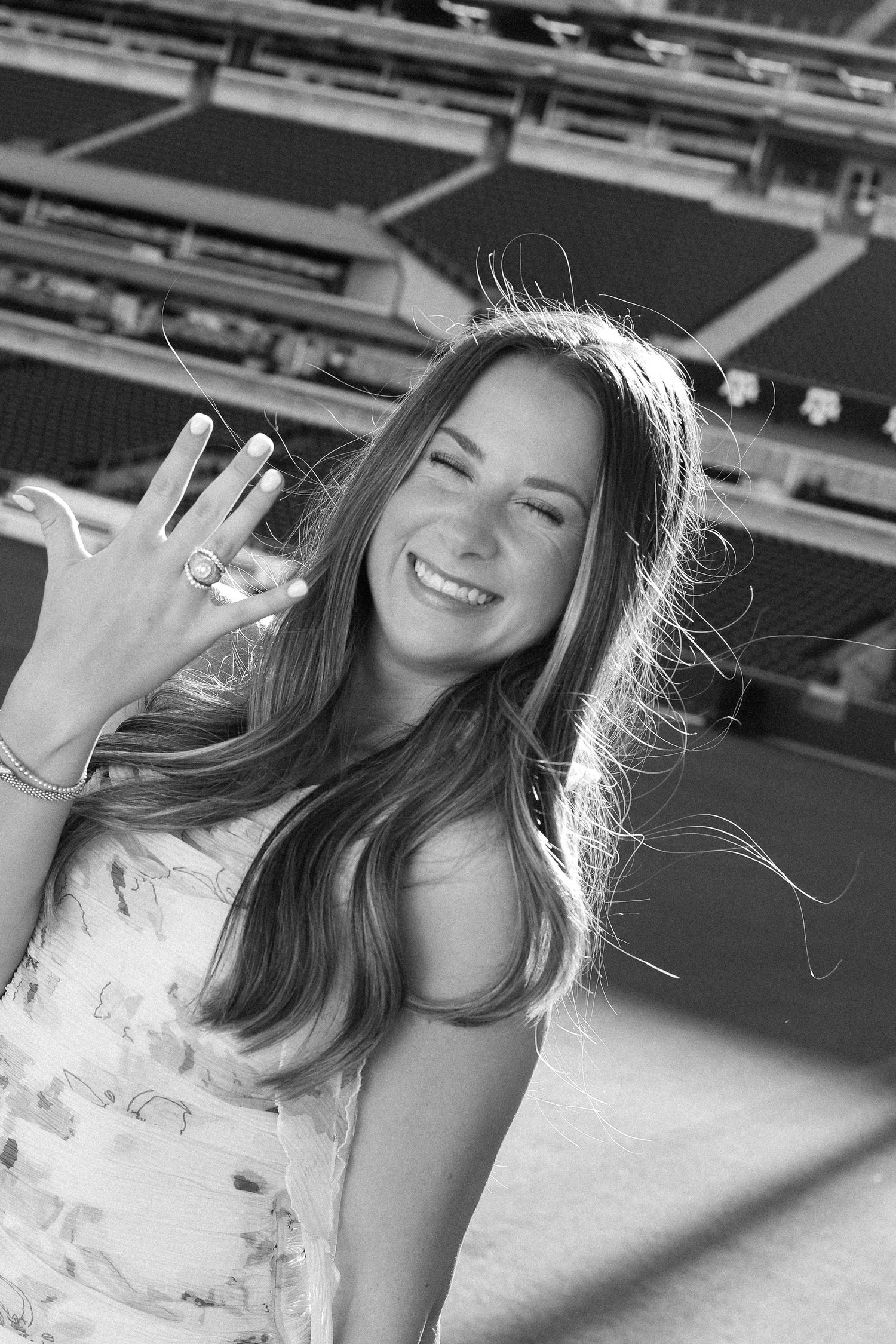 Black and white series of joyful poses in floral dress at stadium.