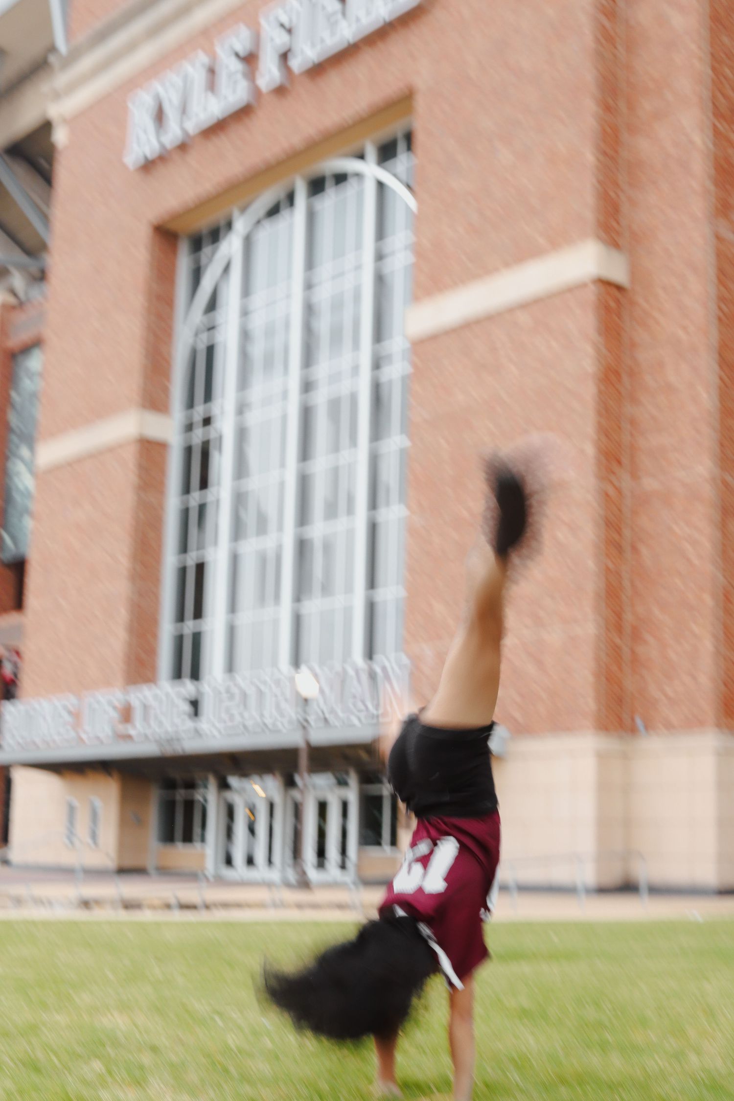 Athletic movement sequence captured against a peach-colored building exterior.