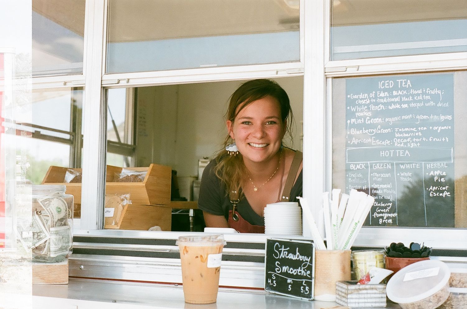 Coffee shop counter with chalkboard menus and service window.