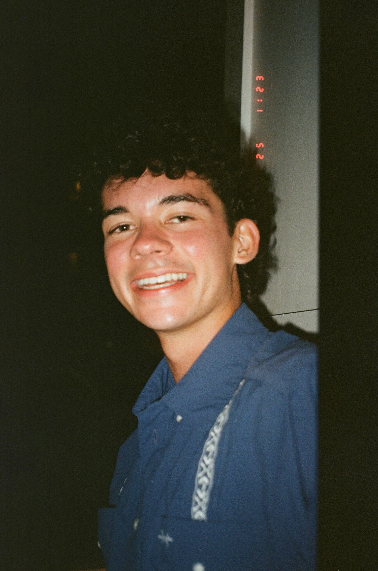 A series of vintage-style flash photos showing someone wearing a blue jacket smiling in dim lighting conditions.