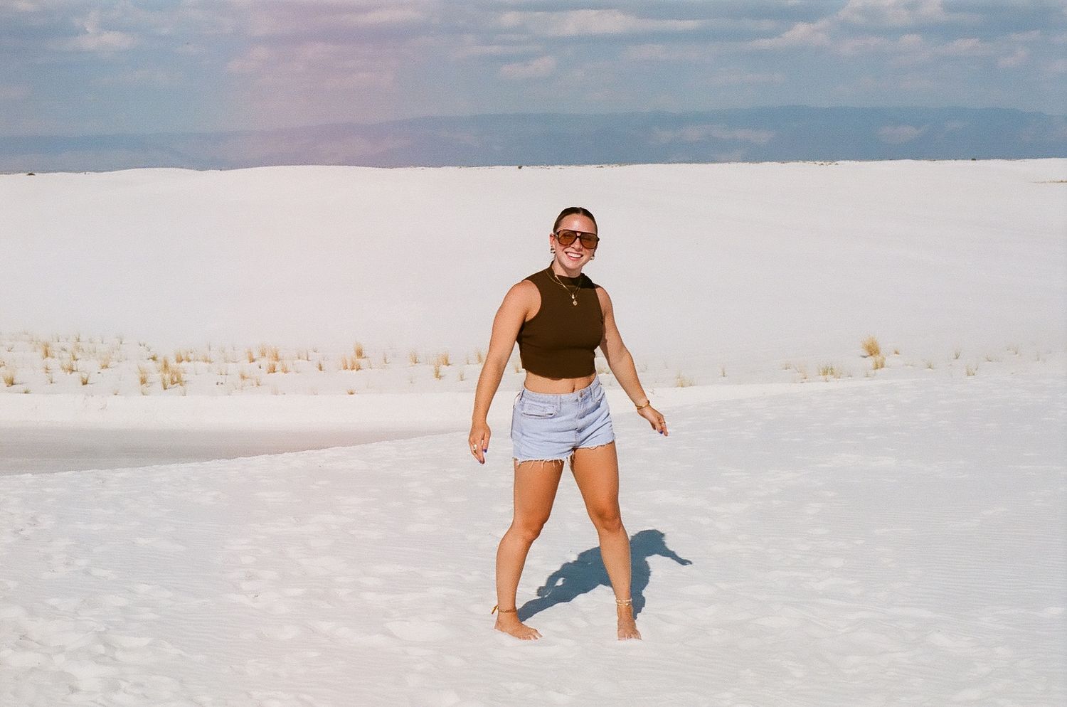 A series of people walking and playing on the pristine white sands of White Sands National Park in New Mexico.