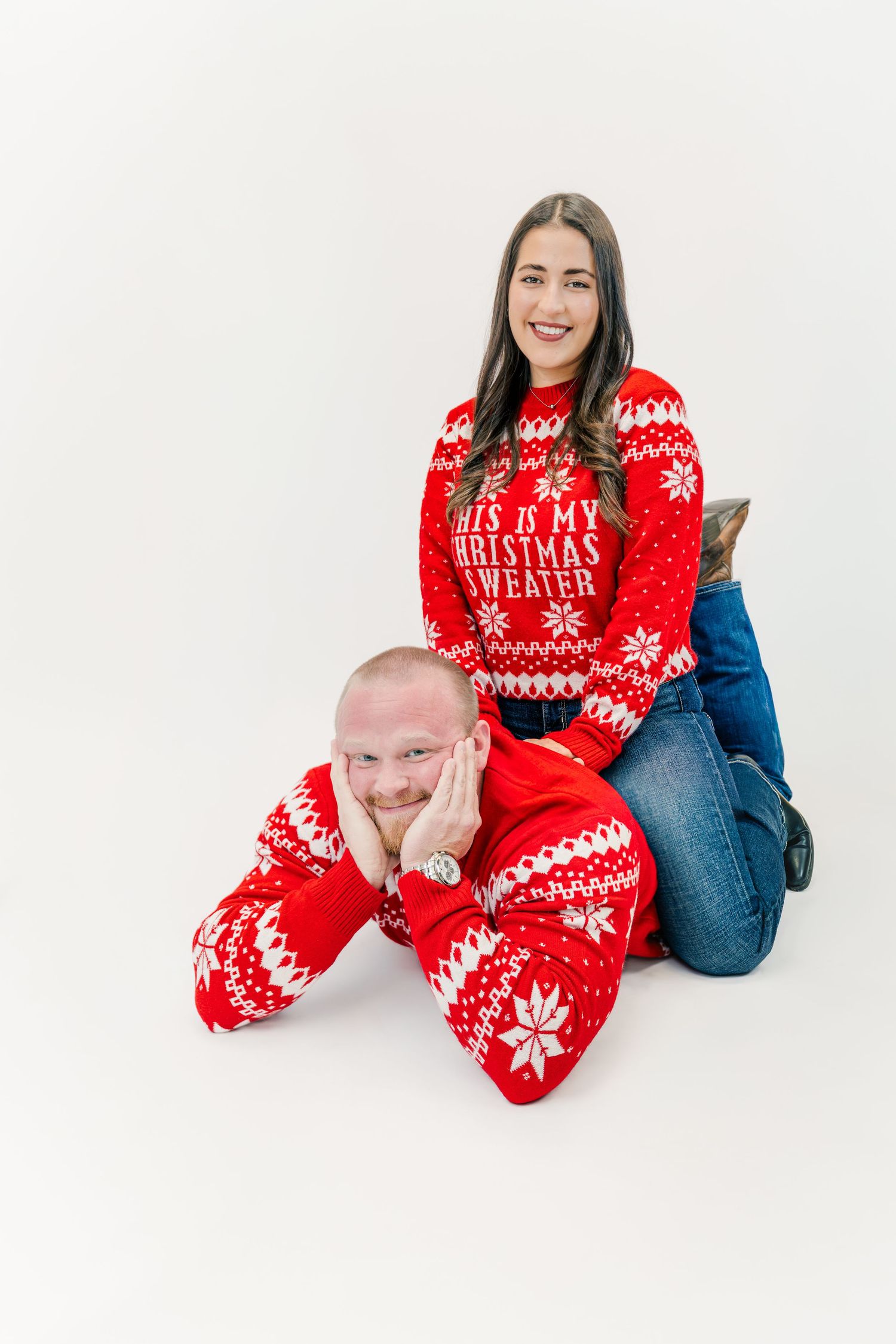 Couple wearing bright red Christmas sweaters with bold patterns that can be distracting in family photos