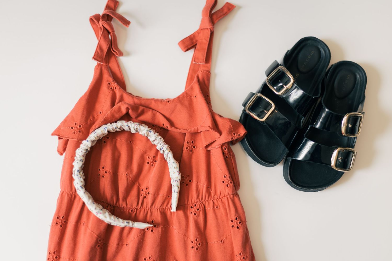 Little girl outfit with rust-colored dress, headband, and sandals styled for family photos