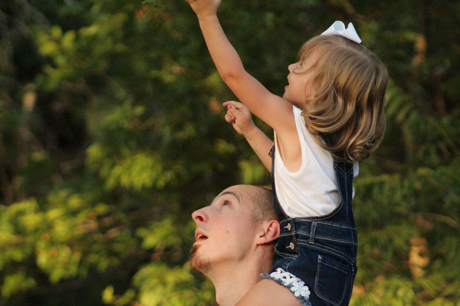 Father holding his daughter’s hands during a warm outdoor family session in Murfreesboro, Tennessee.