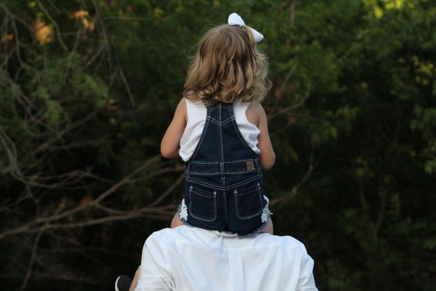 Dad carrying his daughter on his shoulders during a golden hour family photography session in Rutherford County.