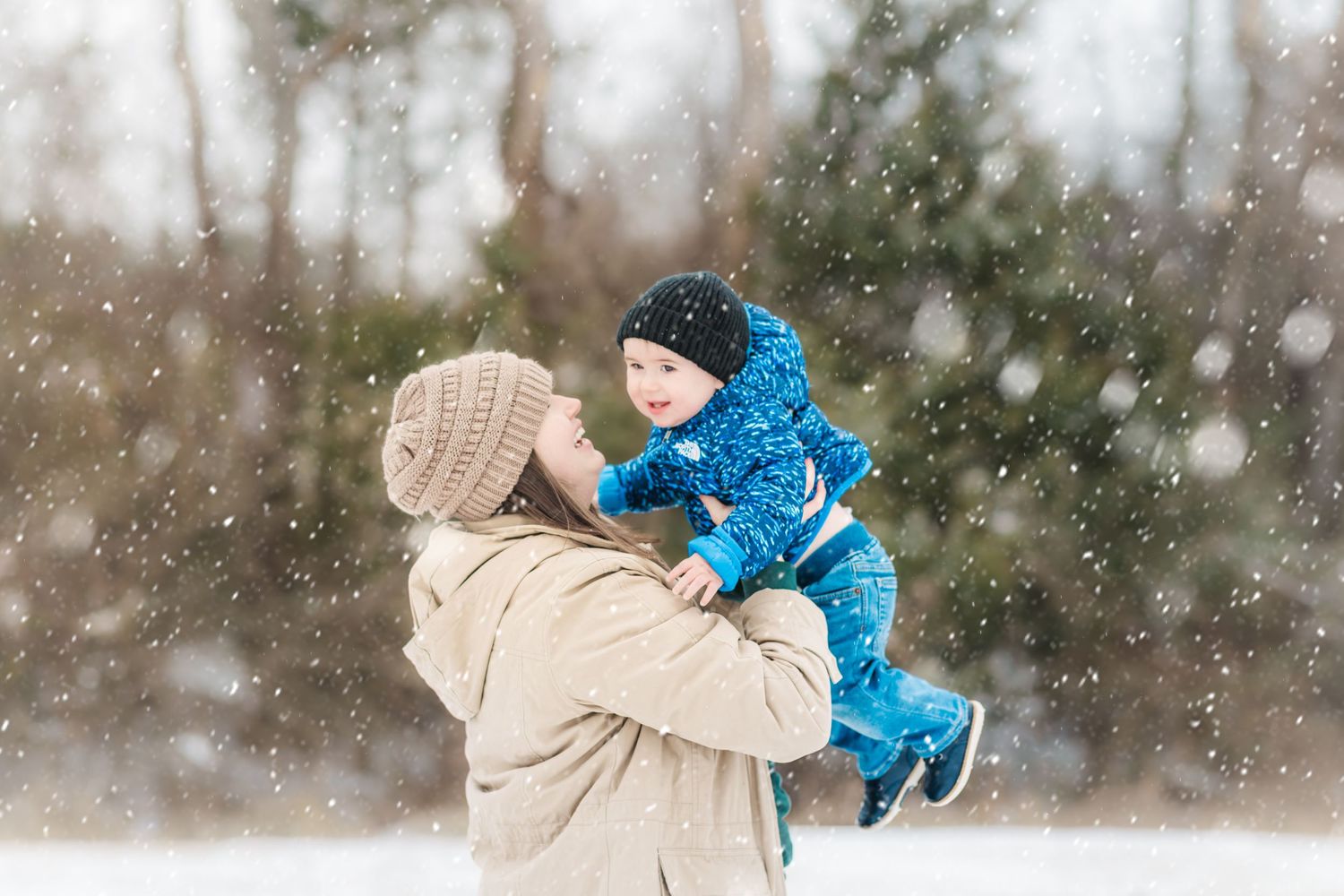 Winter family photography session in Murfreesboro Tennessee with mother lifting her child in the snow