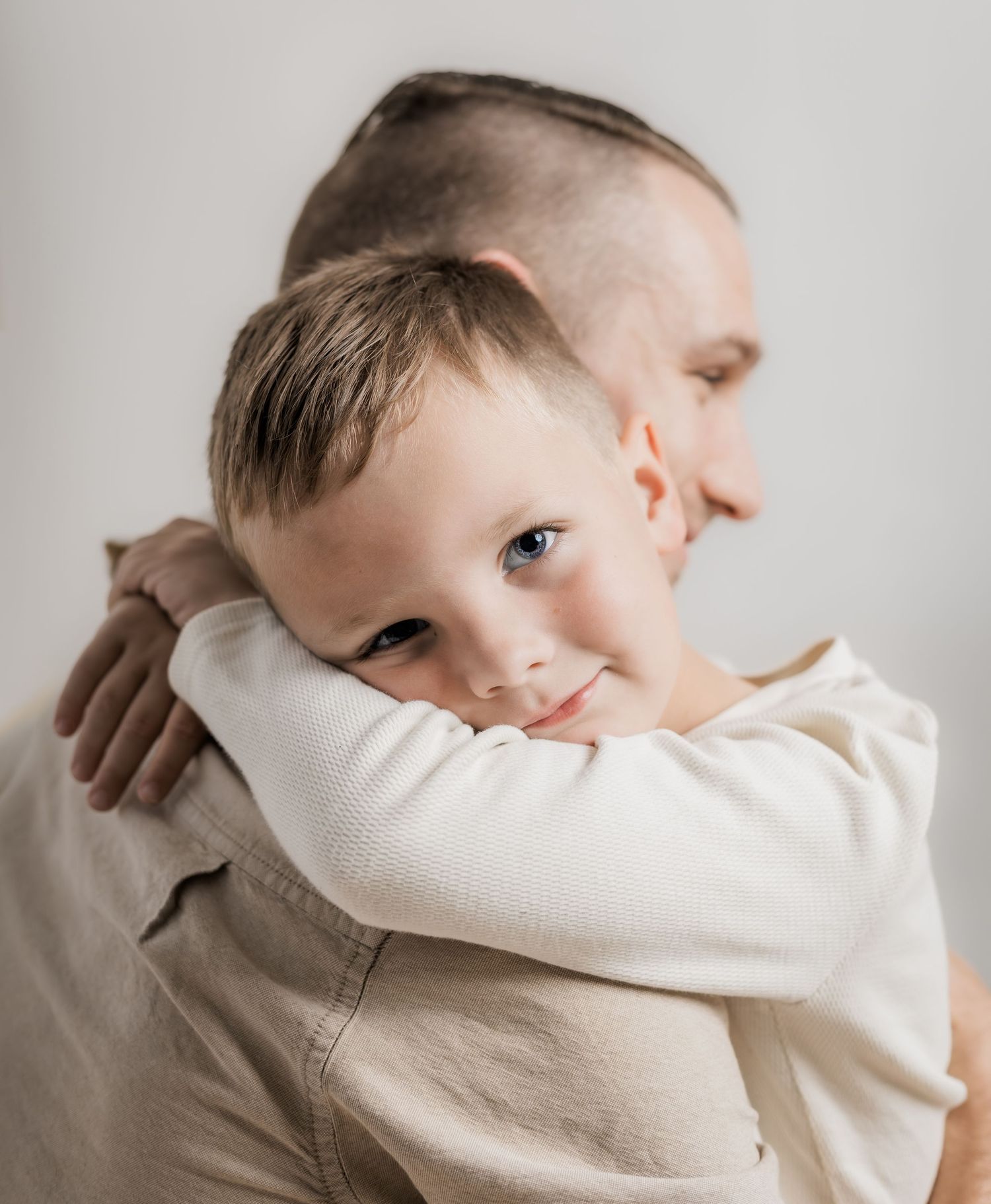 A child in a cream colored sweater rests their head against a white surface in a series of connected photos by a Murfreesboro photographer.